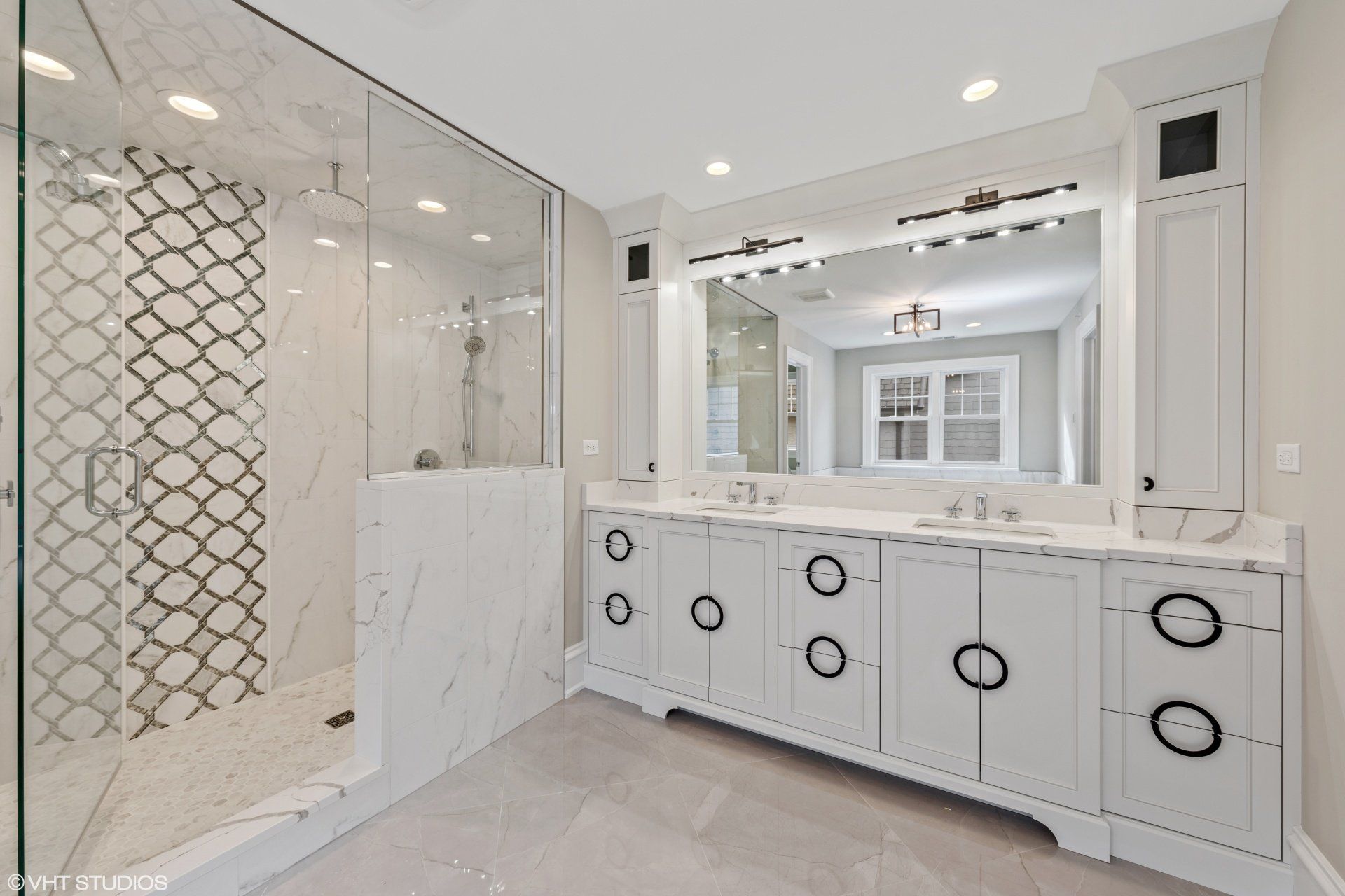 A bathroom with two sinks and a walk in shower