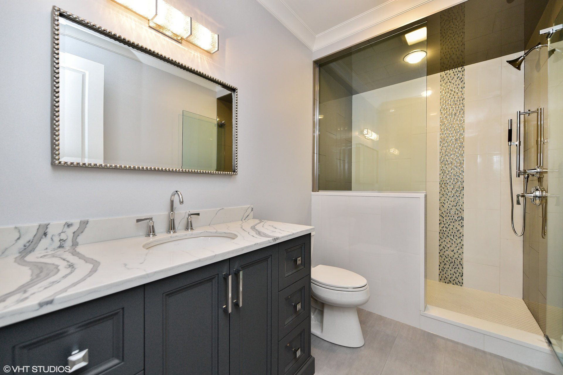 A bathroom with a toilet , sink , mirror and shower.