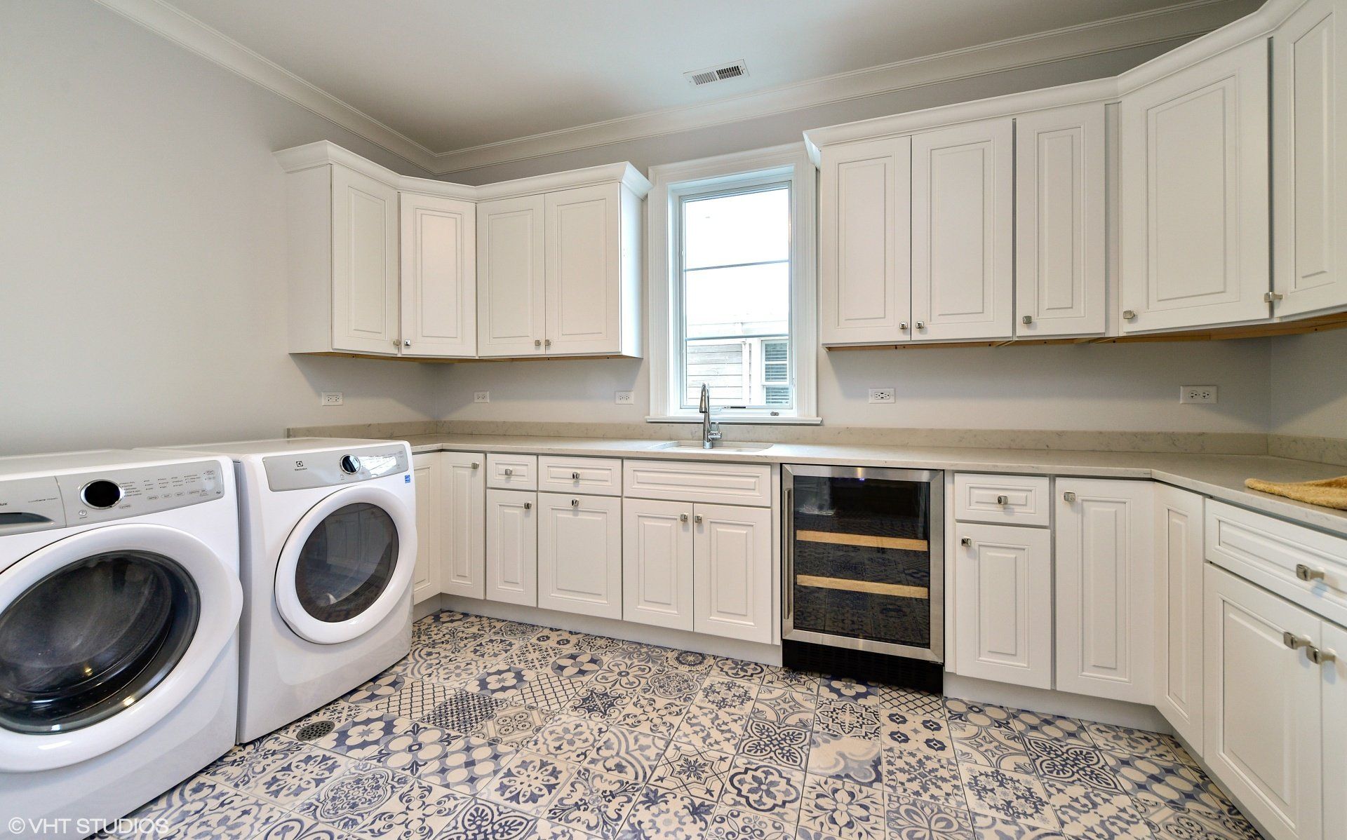 A laundry room with white cabinets and a washer and dryer