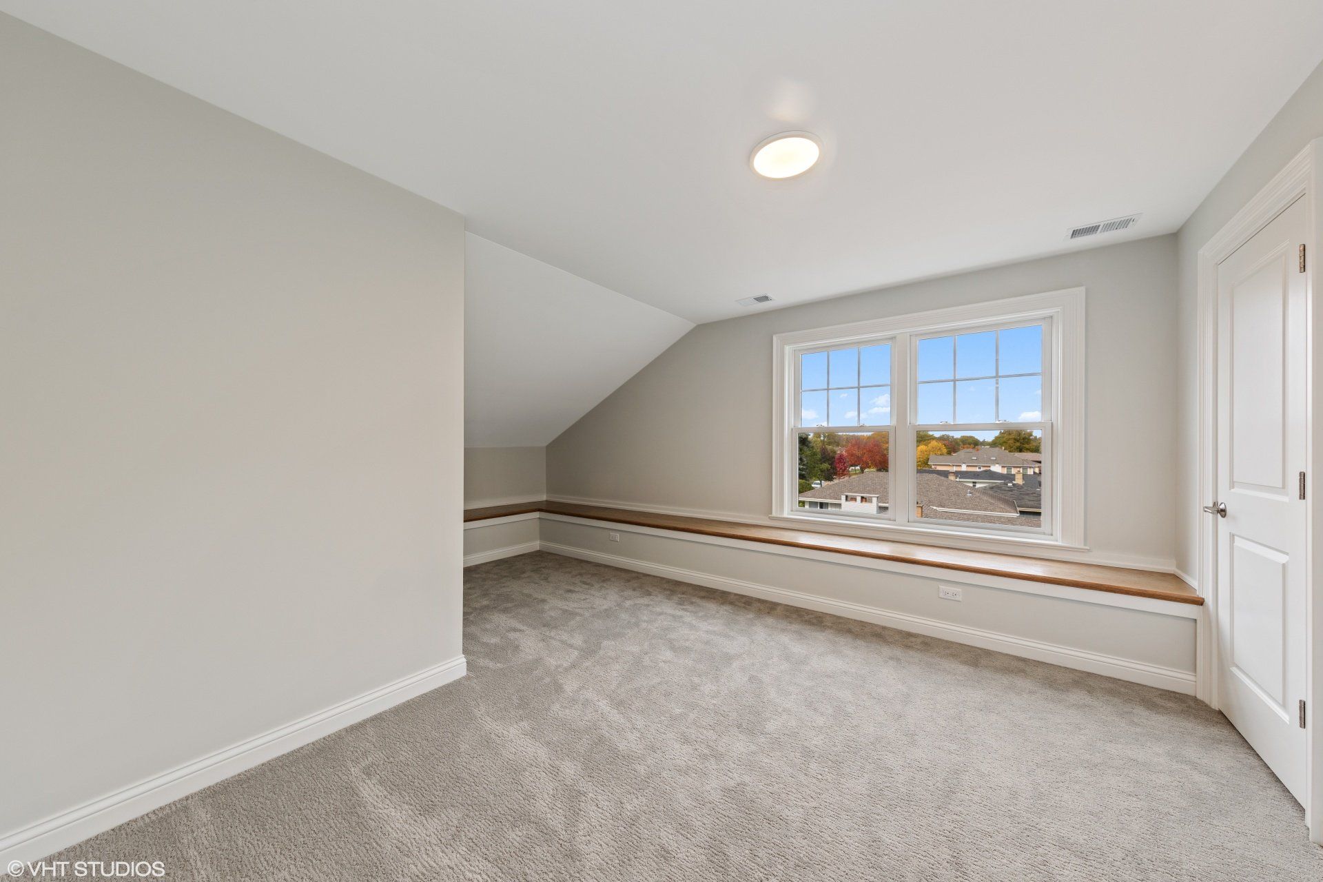An empty room with a window and a bench.