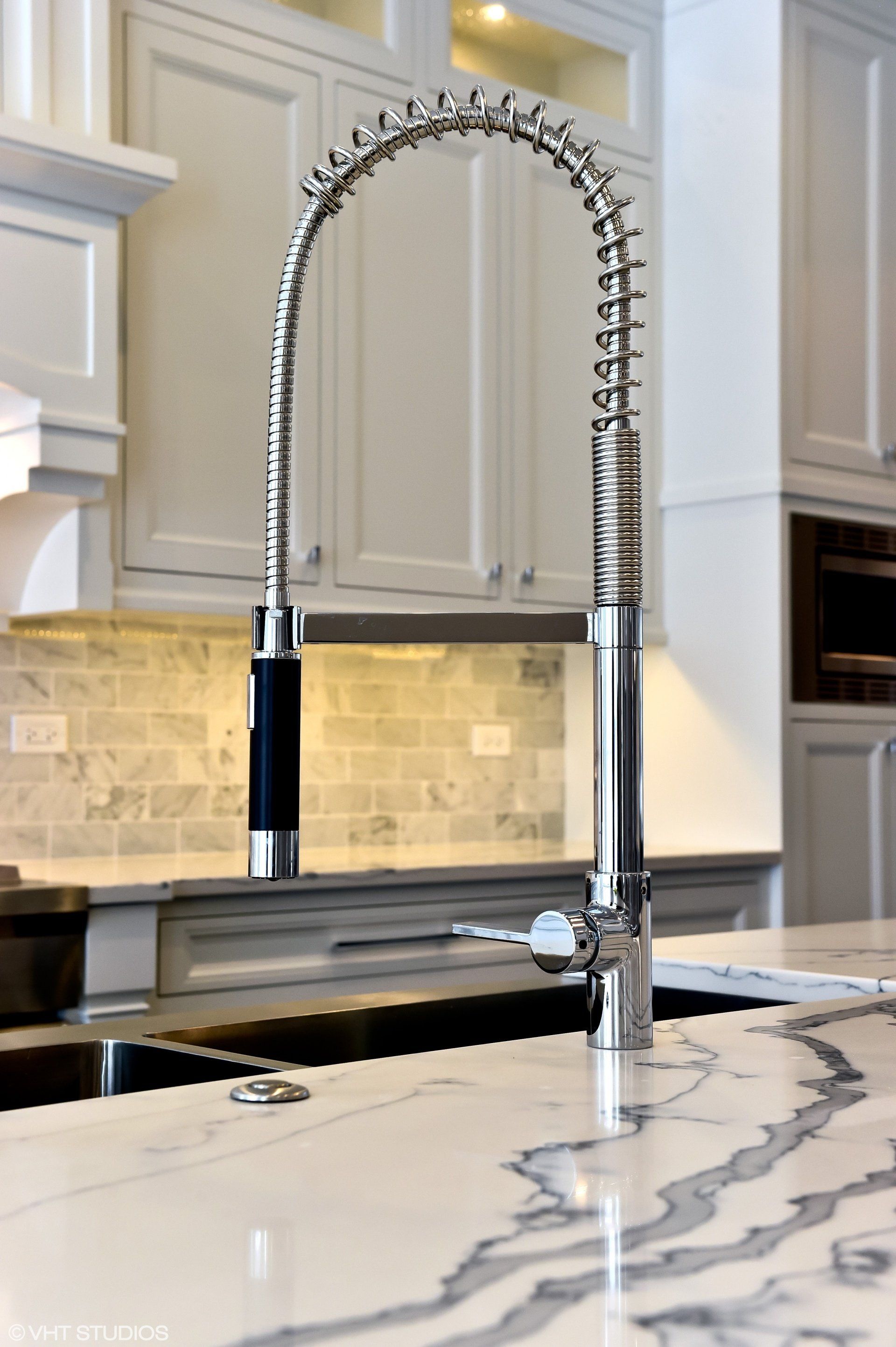 A kitchen sink with a faucet on top of it