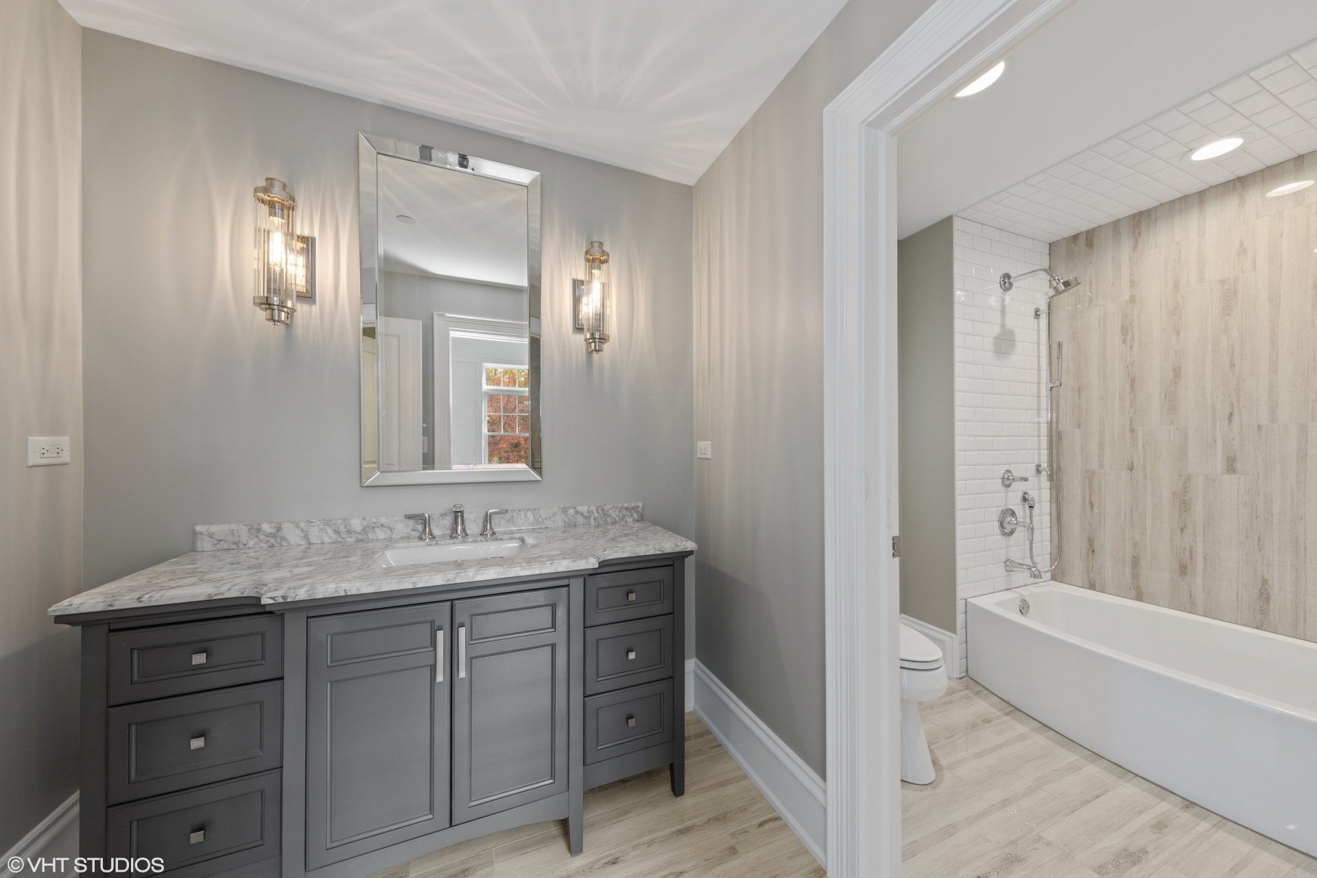 A bathroom with a sink , mirror , toilet and bathtub.