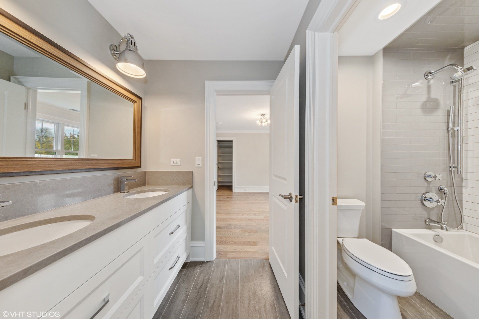 A bathroom with a toilet , sink , mirror and tub.