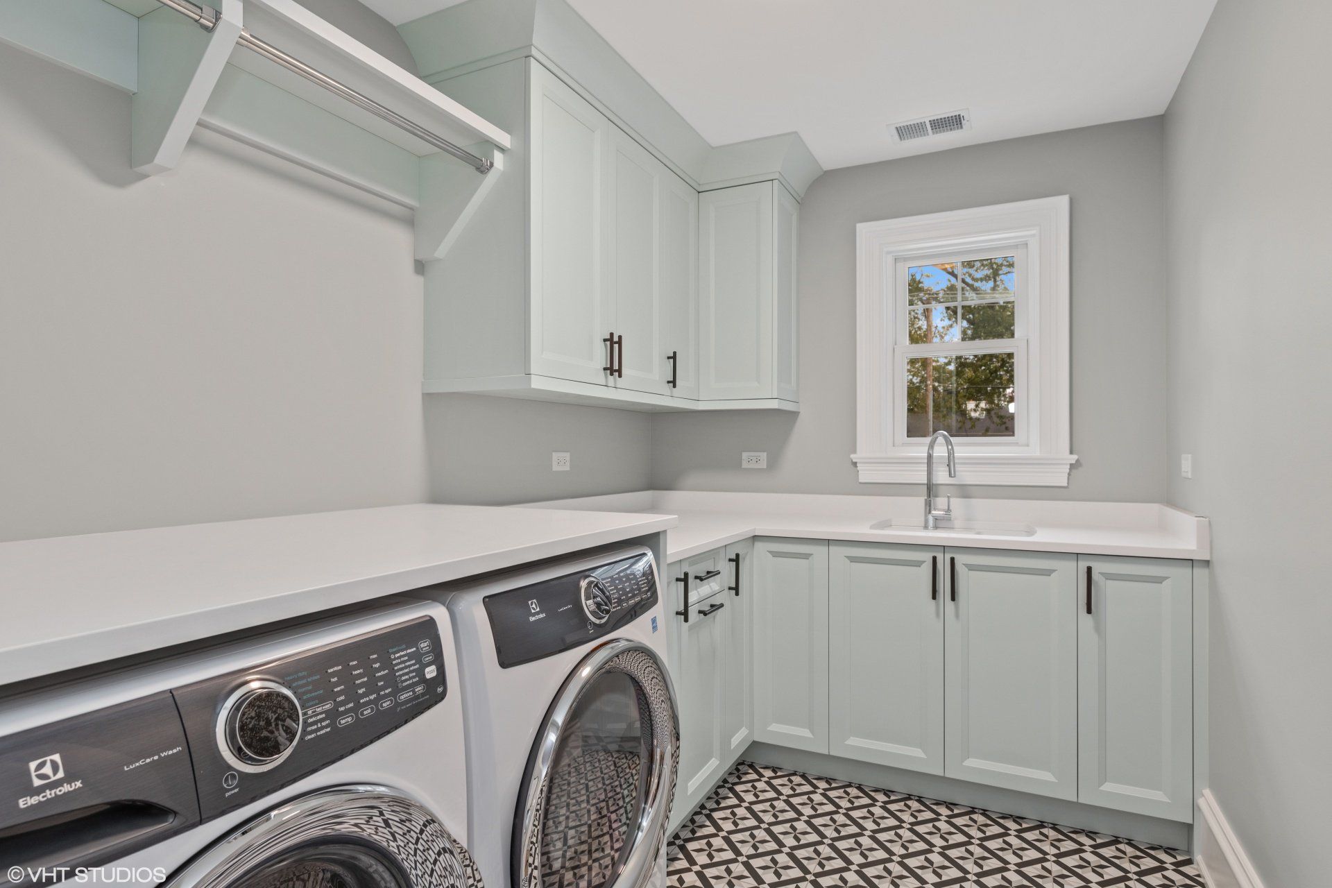 A laundry room with a washer and dryer and a sink.