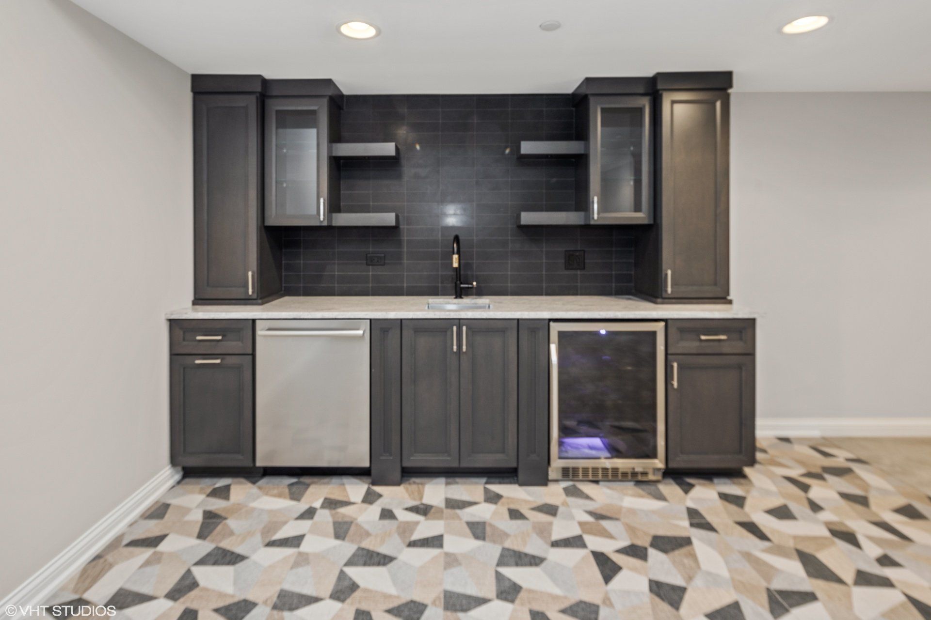 A kitchen with gray cabinets and a stainless steel refrigerator