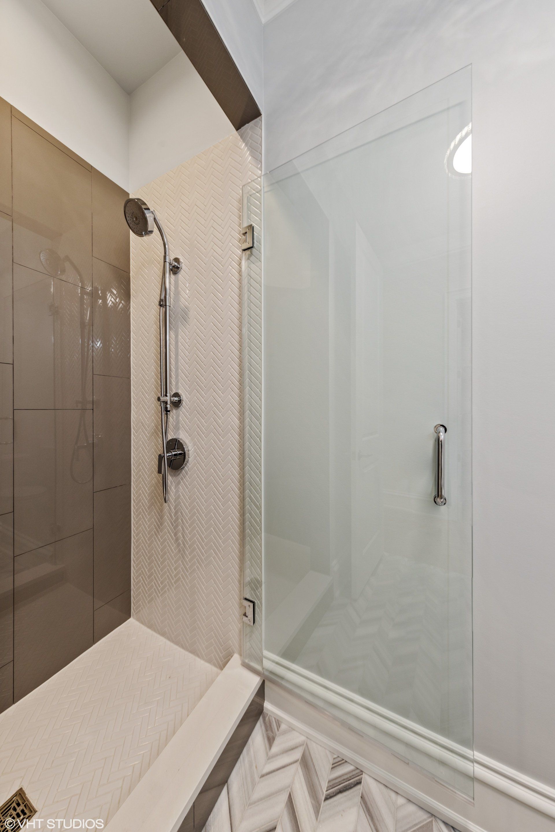 A bathroom with a walk in shower and a glass door.