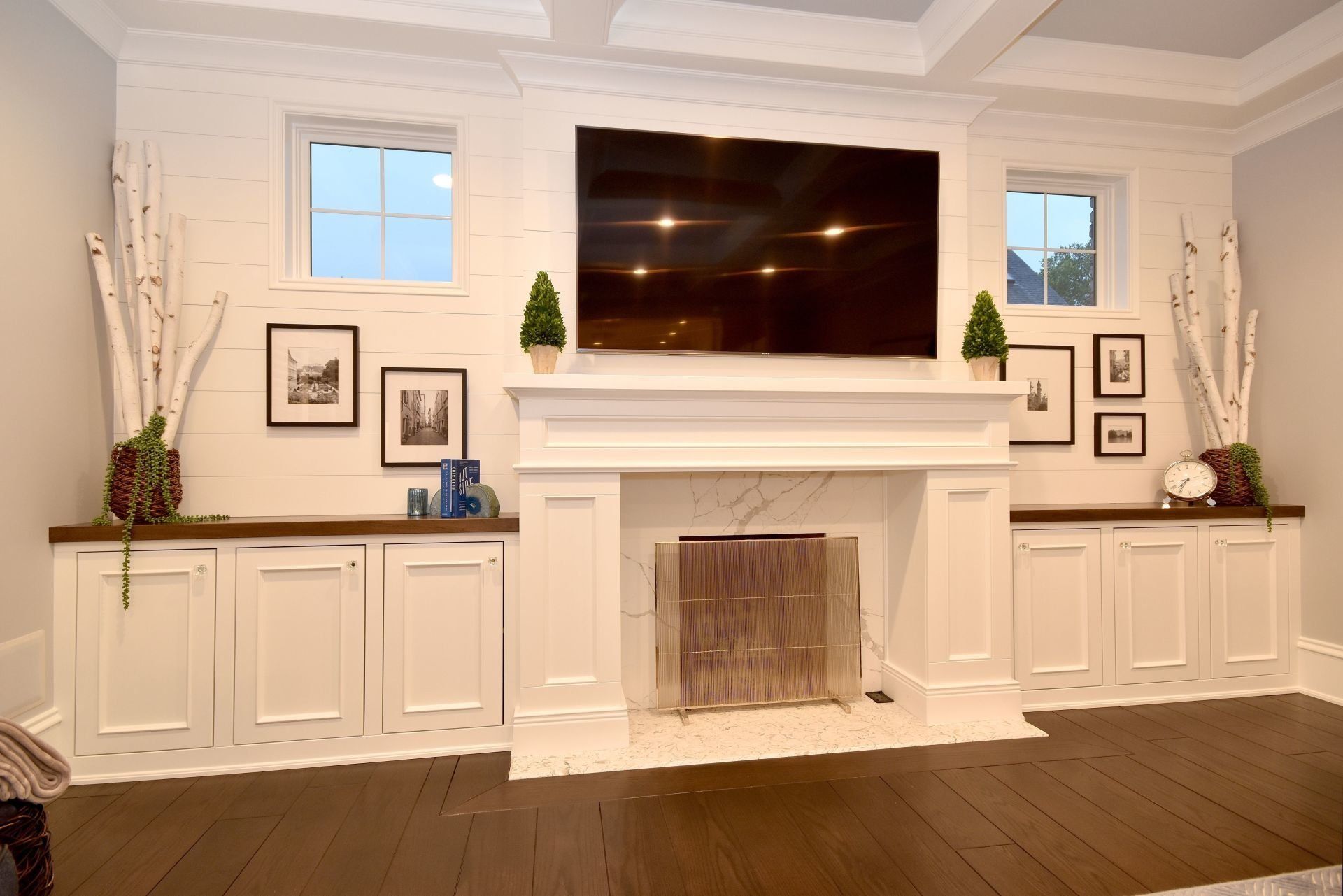A living room with a fireplace and a flat screen tv on the wall.