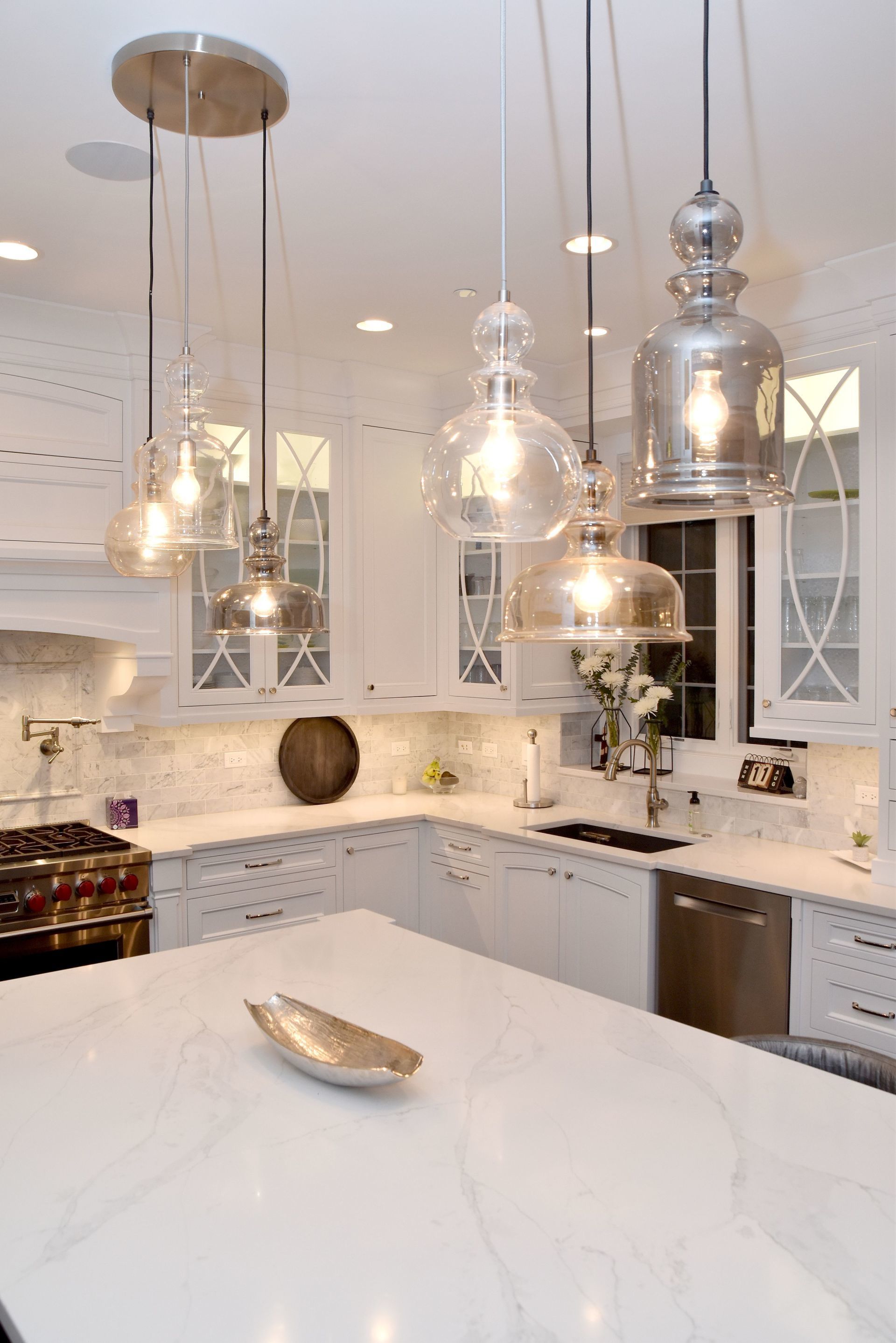 A kitchen with white cabinets and marble counter tops