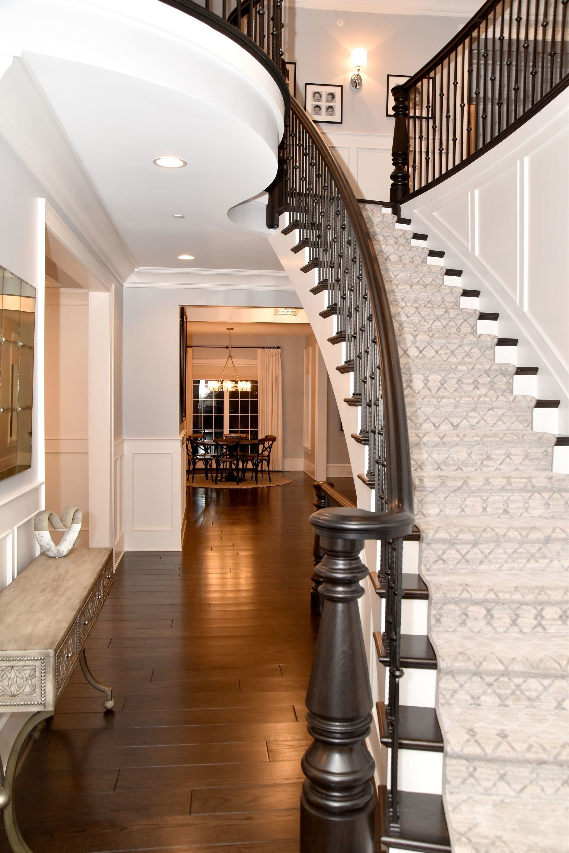 A curved staircase in a house with a black railing