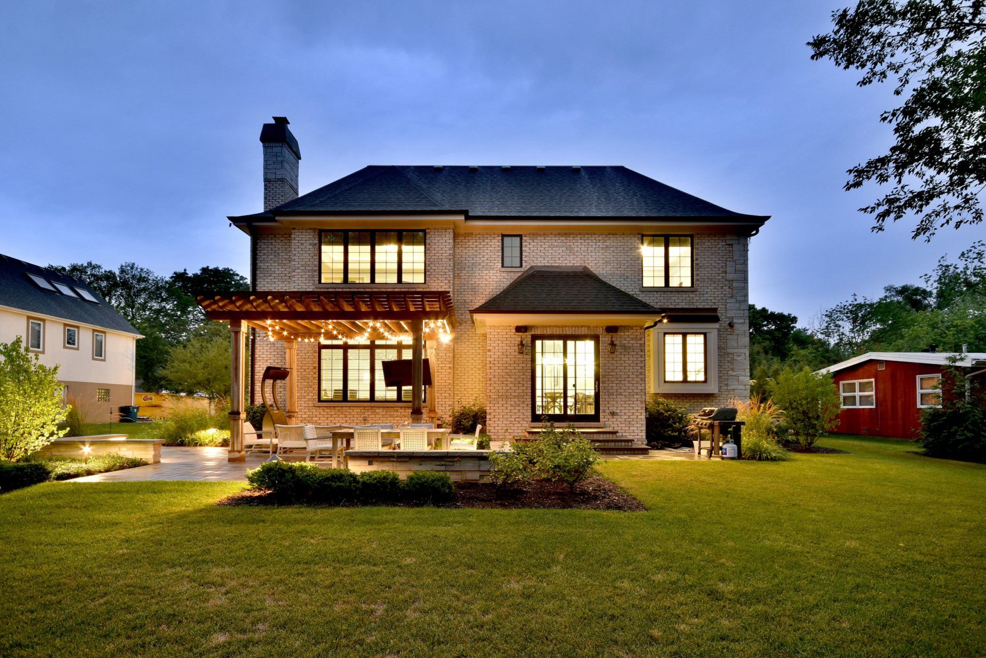 A large brick house with a large lawn in front of it