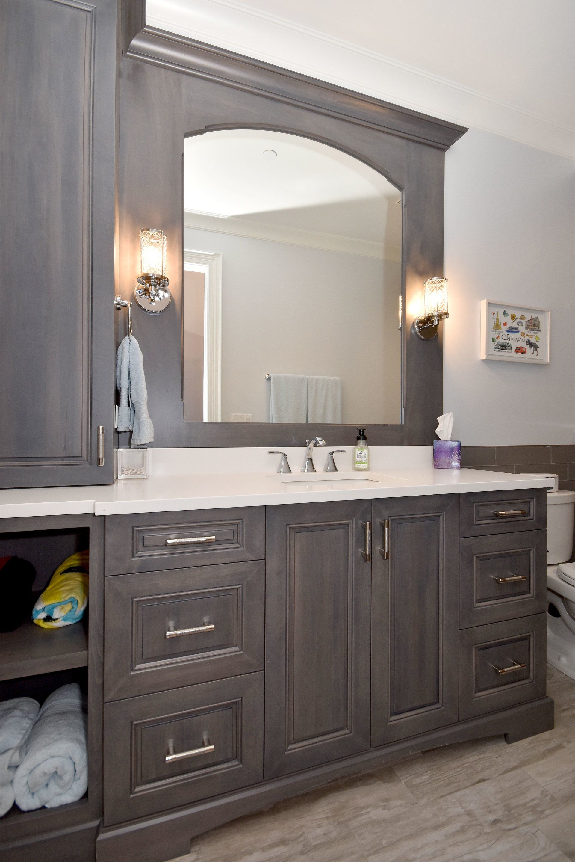 A bathroom with a sink , mirror and cabinets.