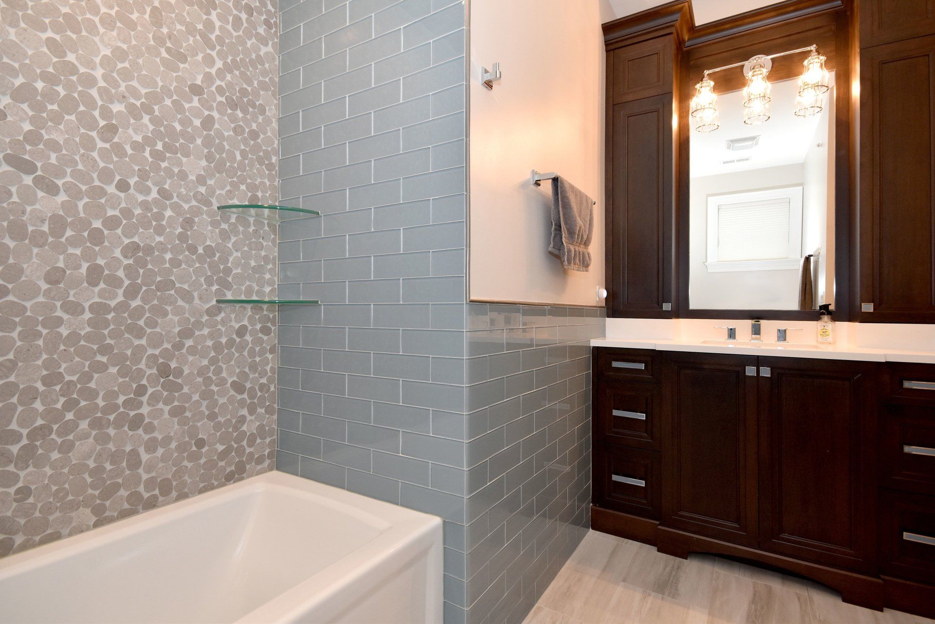 A bathroom with a tub , sink and mirror