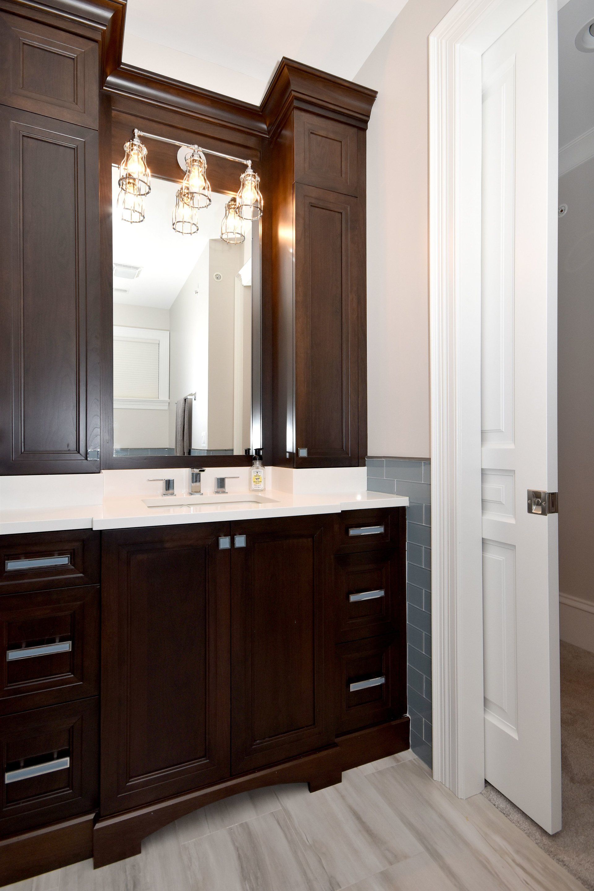 A bathroom with a sink , mirror and cabinets.