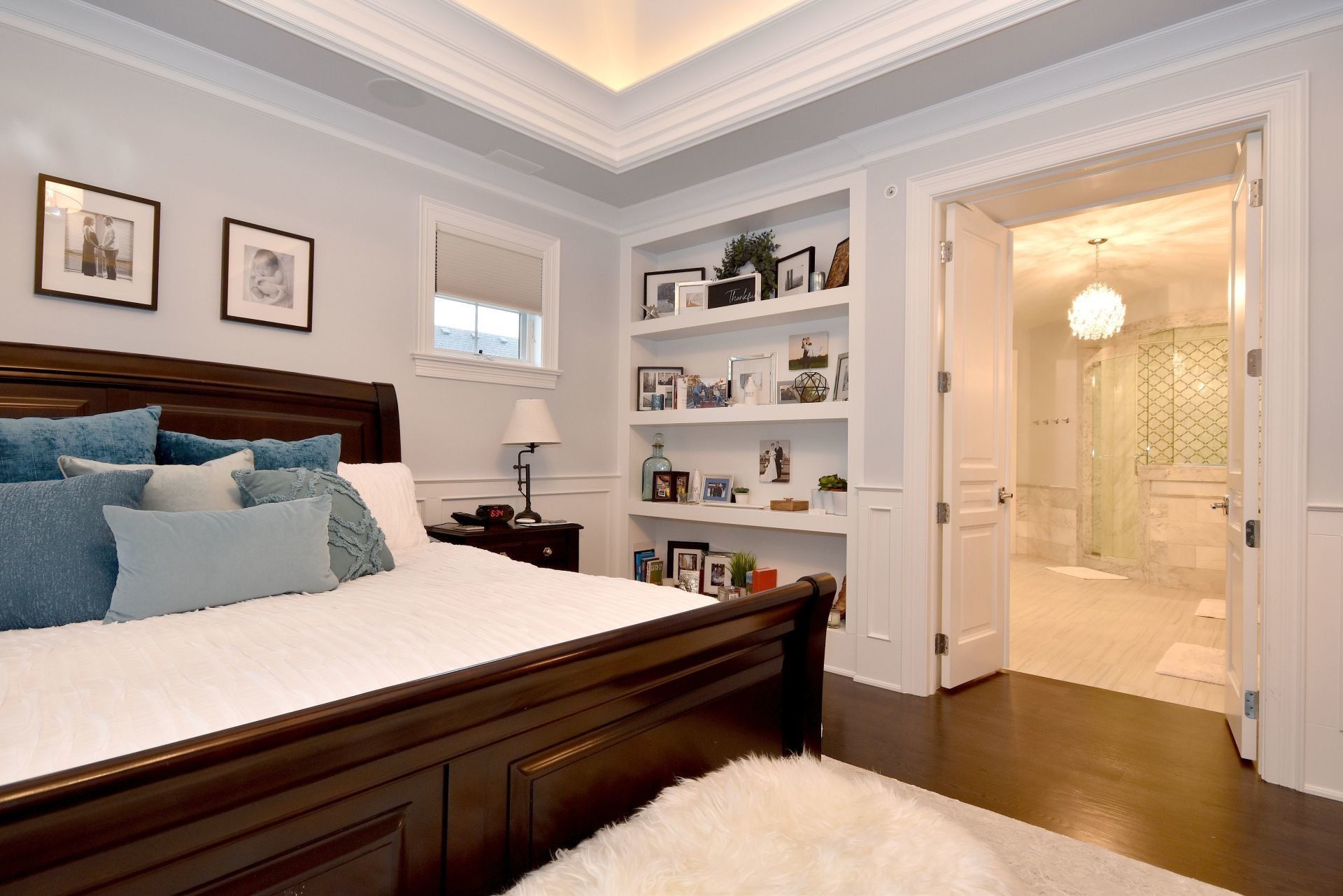 A bedroom with a bed , shelves , and a bathroom.