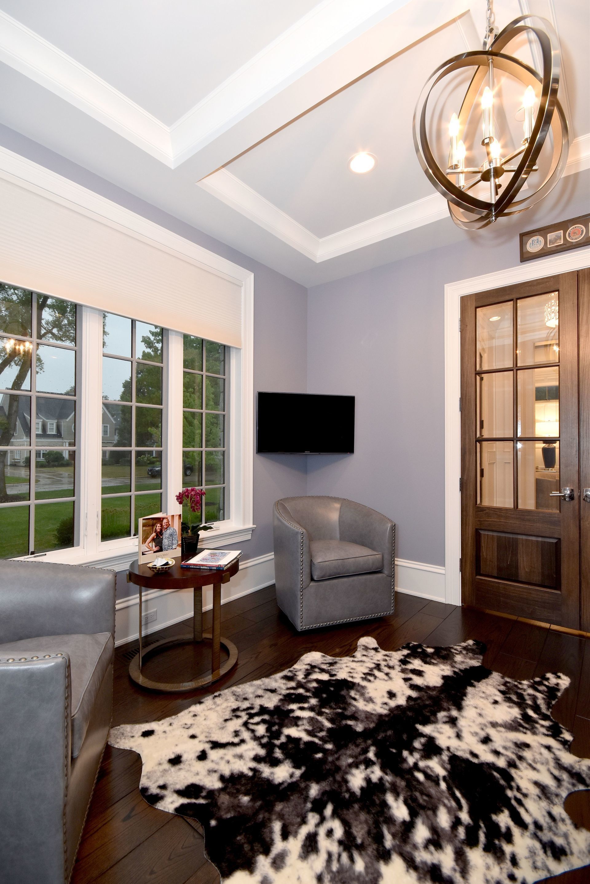 A living room with a cowhide rug and a television