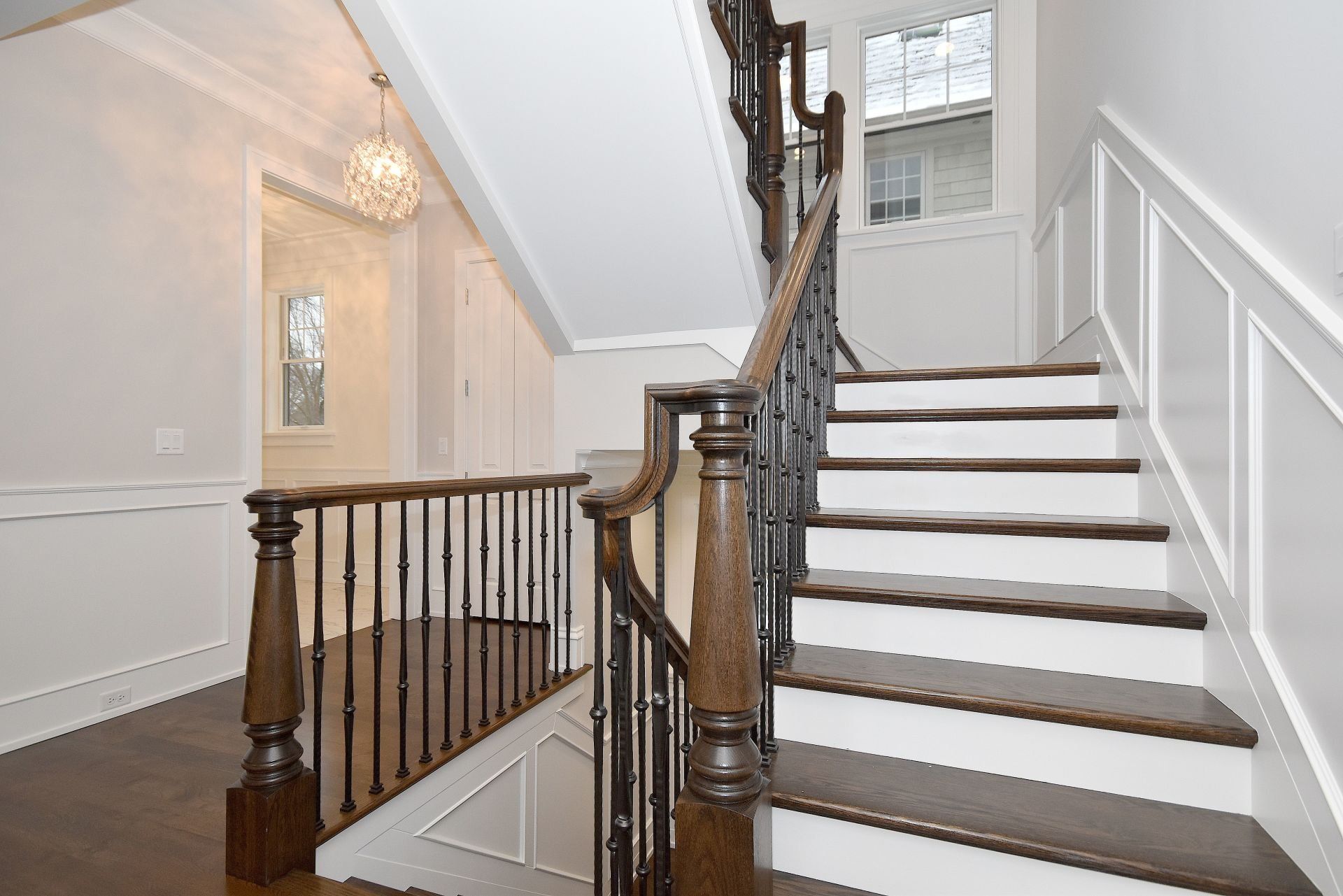 A staircase with white steps and a wooden railing in a house.