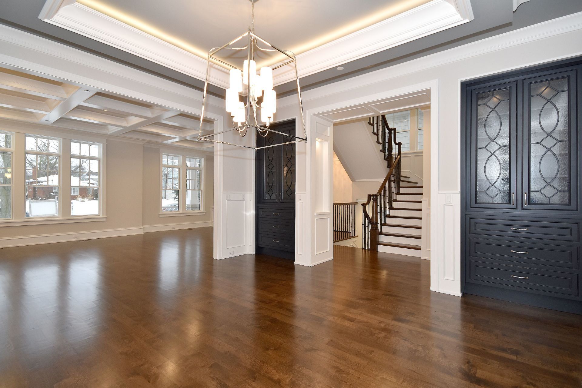 A large empty room with hardwood floors and a staircase.