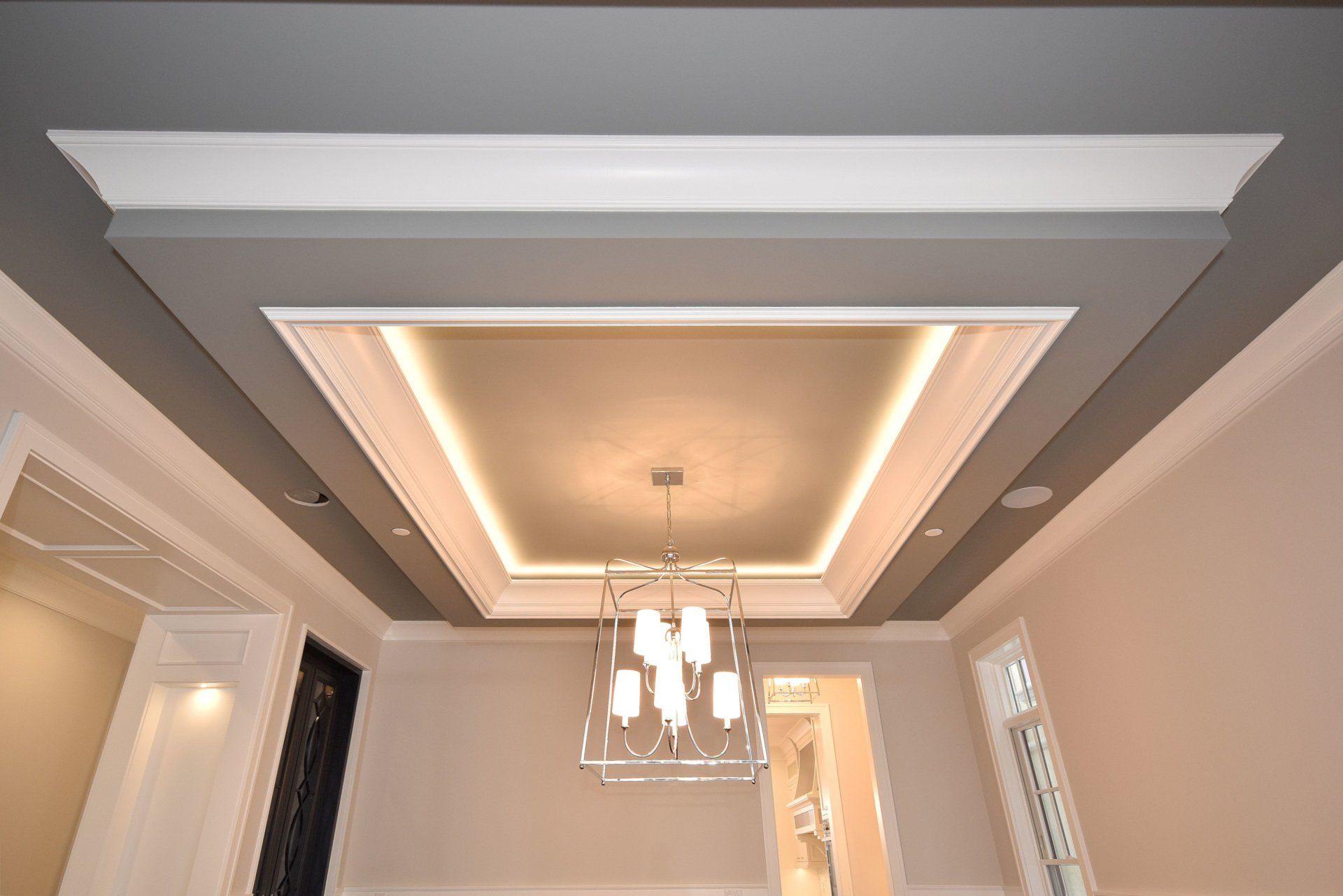 A ceiling with a chandelier hanging from it in a room.