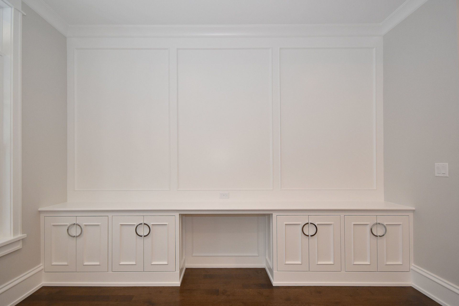 An empty room with a desk and cabinets in it.