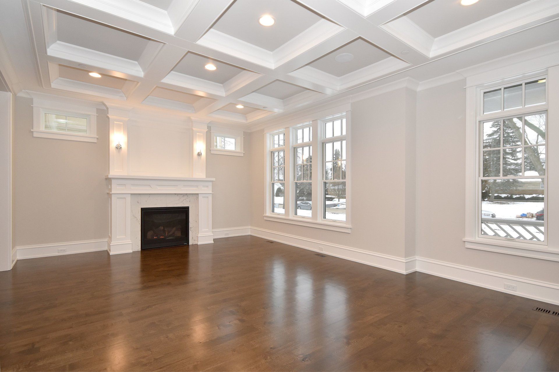 An empty living room with hardwood floors and a fireplace.