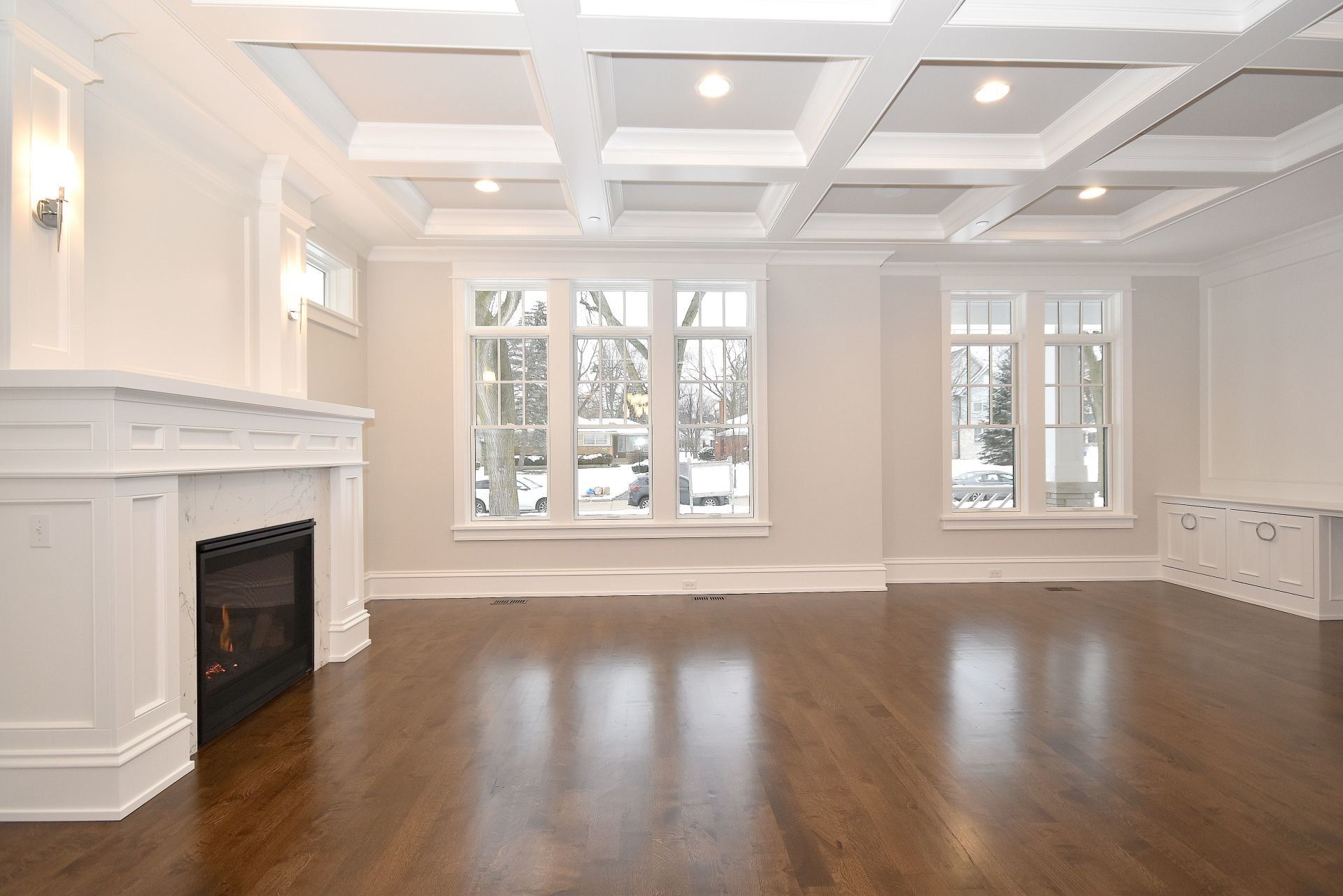 An empty living room with hardwood floors and a fireplace
