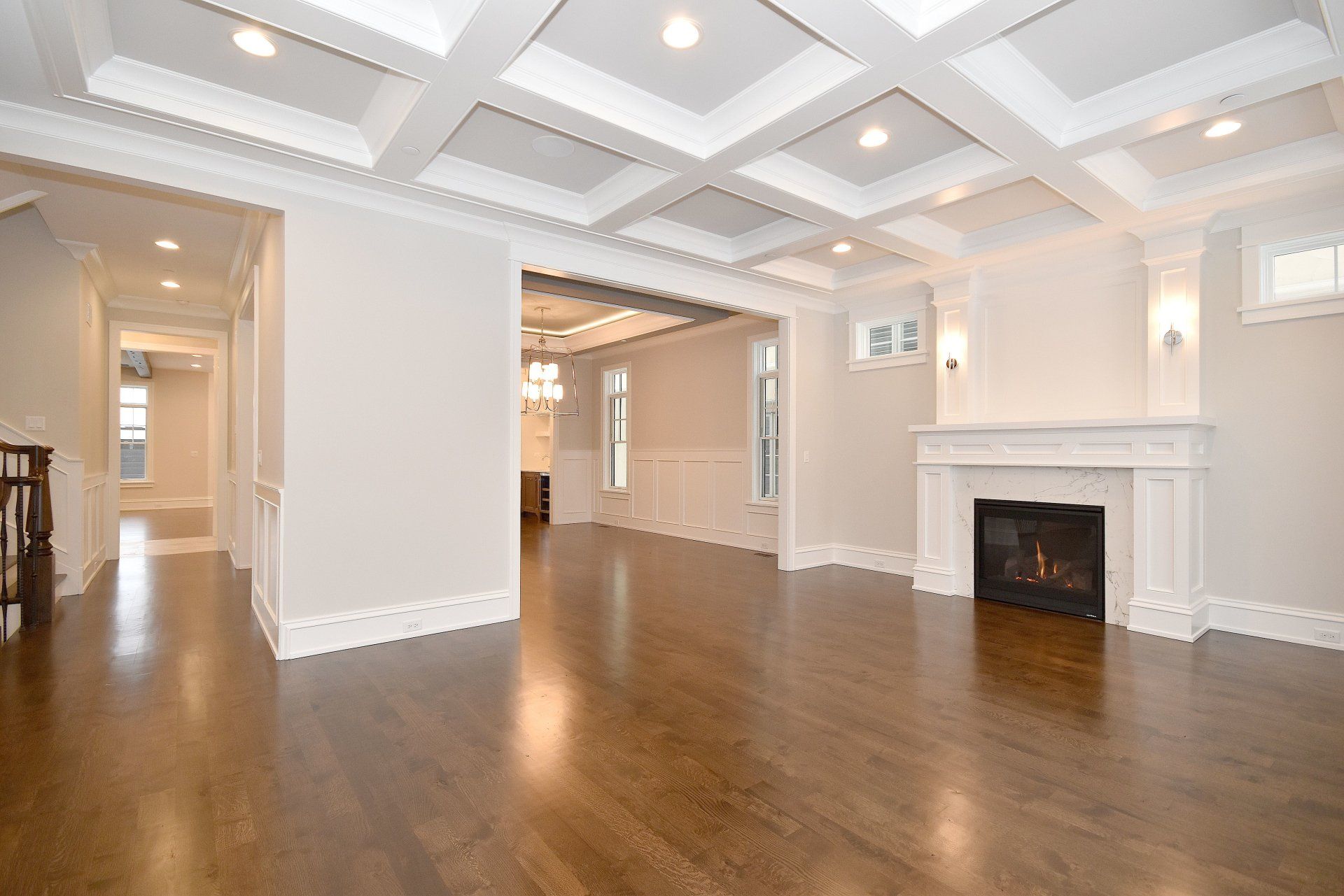 An empty living room with hardwood floors and a fireplace.