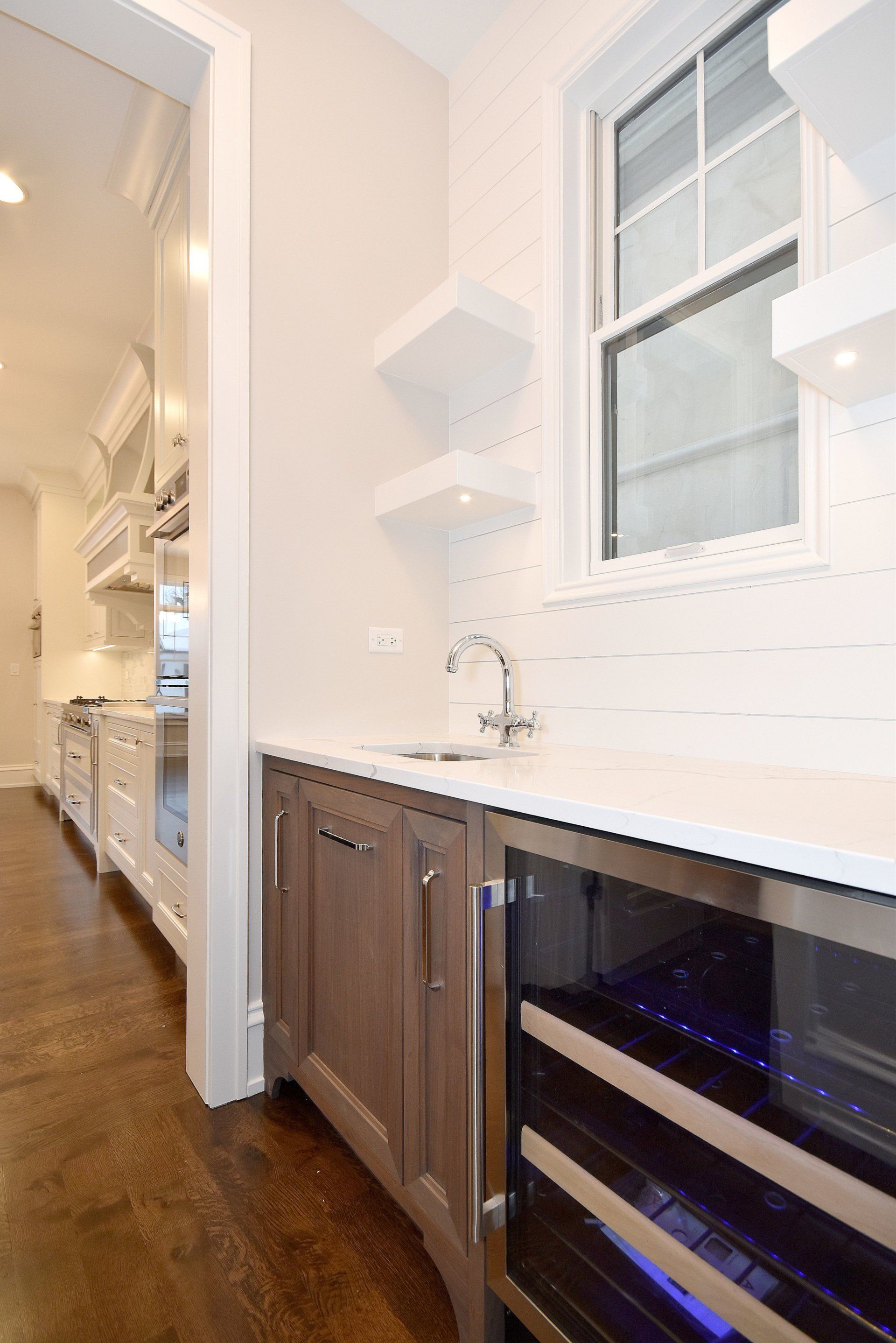 A kitchen with a sink and a wine cooler.
