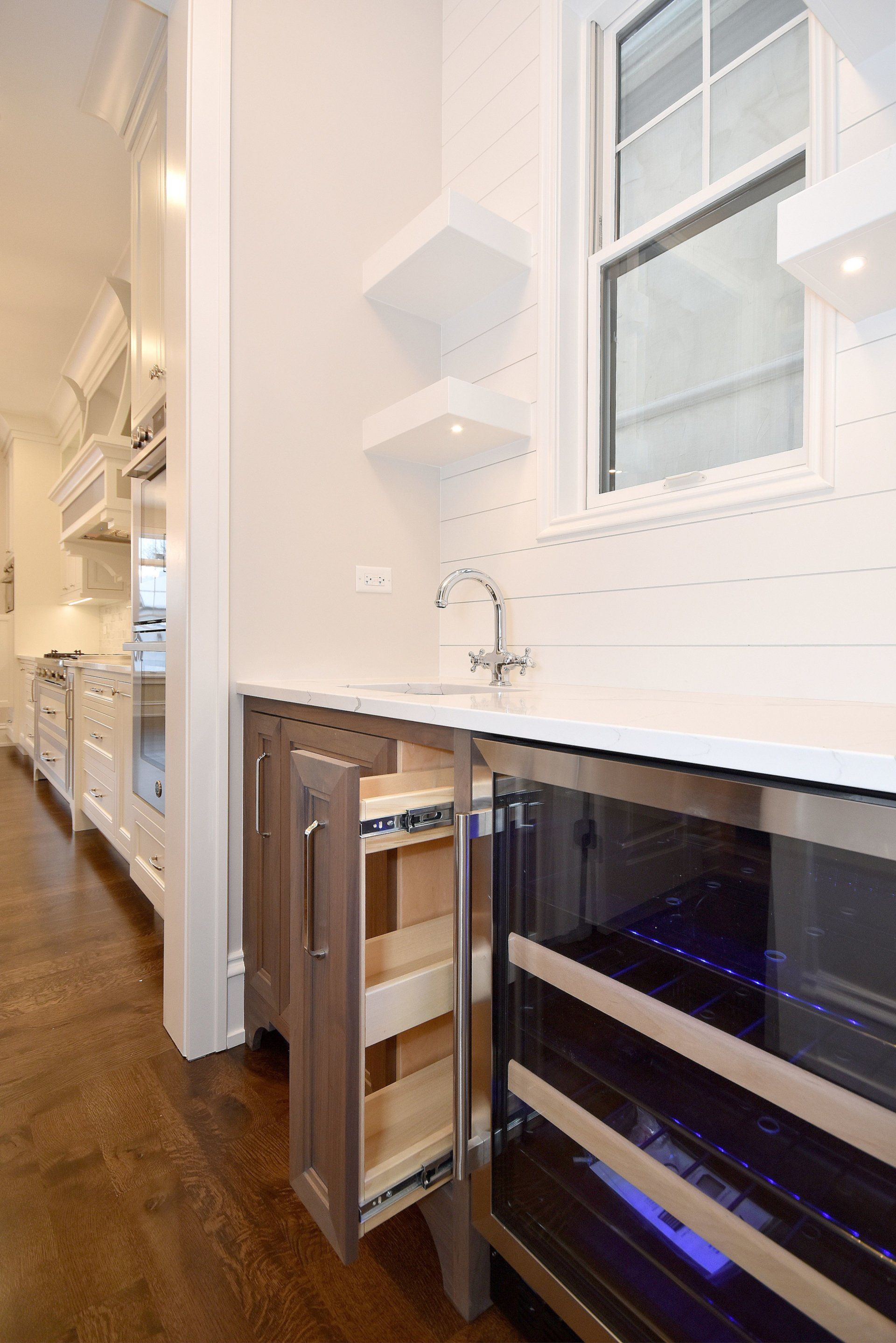 A kitchen with a wine cooler and a pull out drawer.