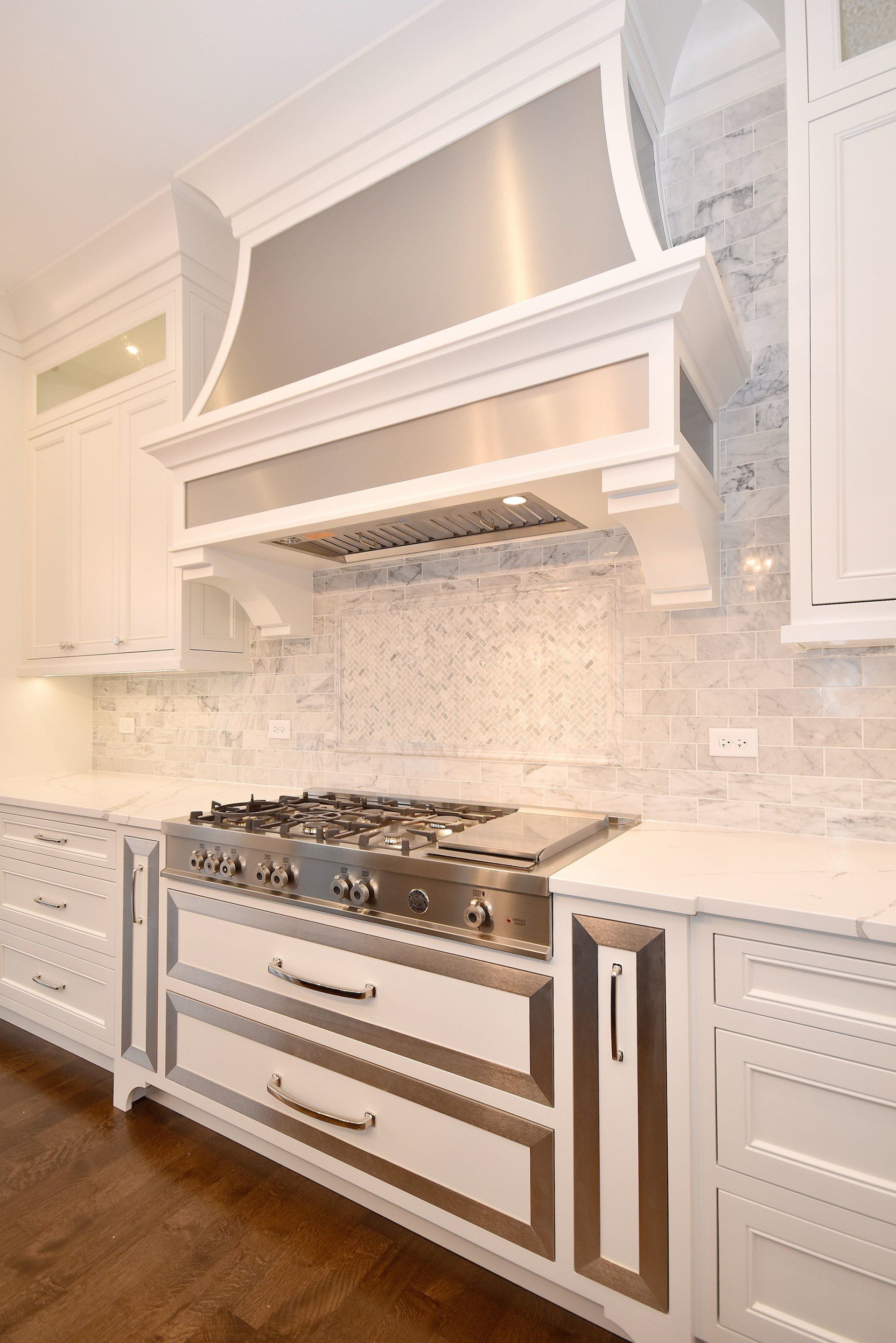 A kitchen with stainless steel appliances and white cabinets