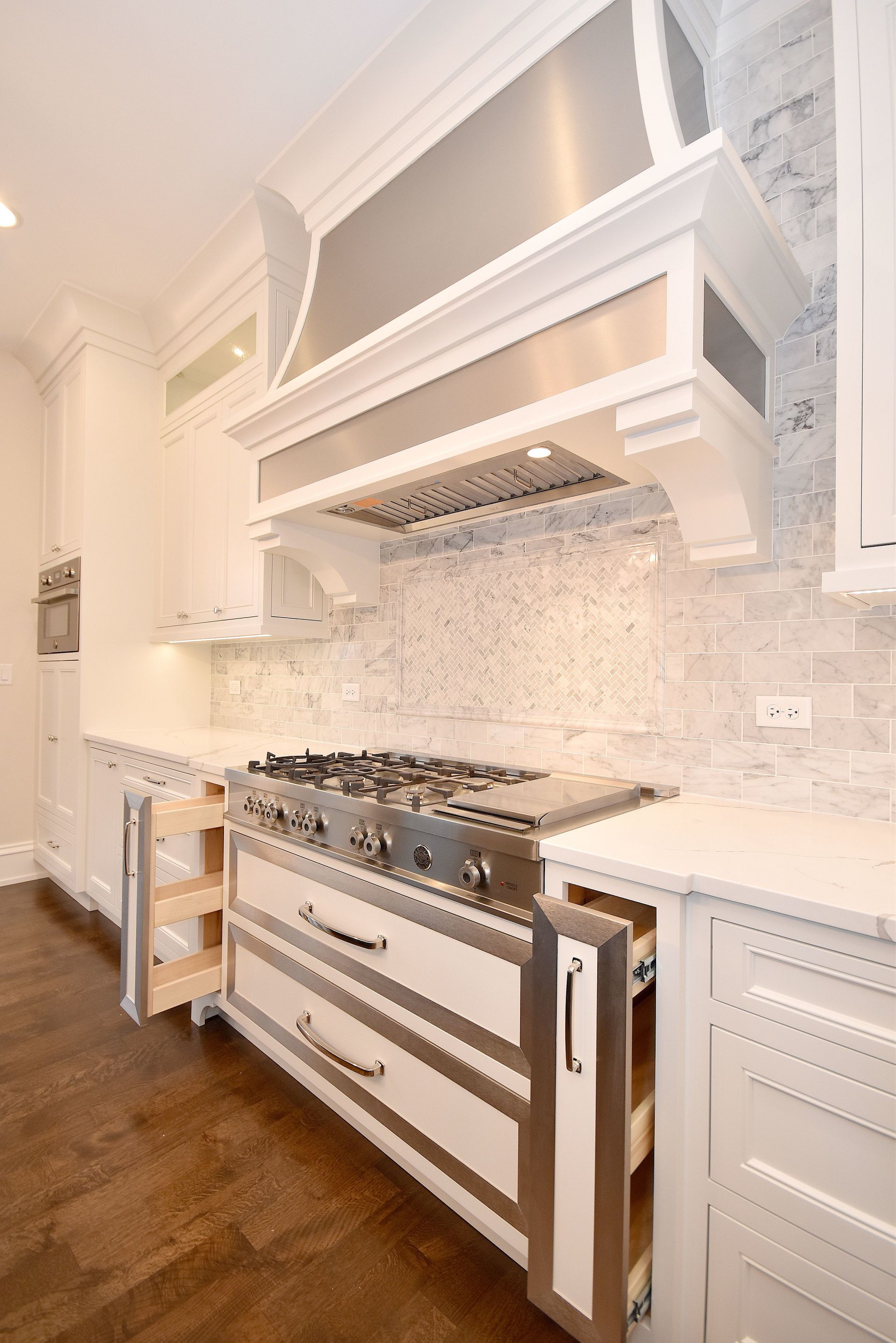 A kitchen with stainless steel appliances and white cabinets.