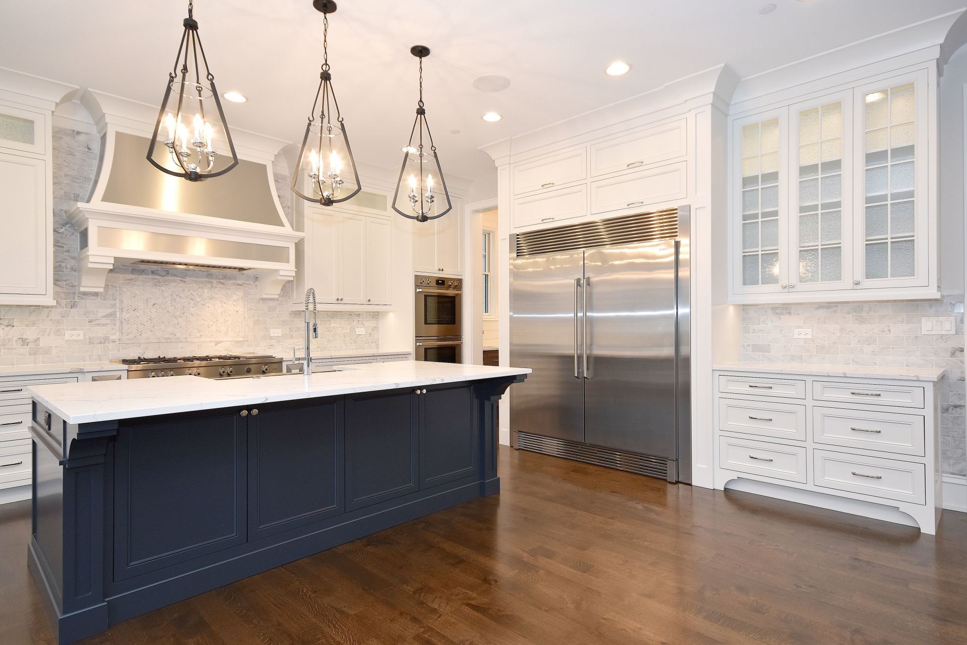 A kitchen with a large island and stainless steel appliances.
