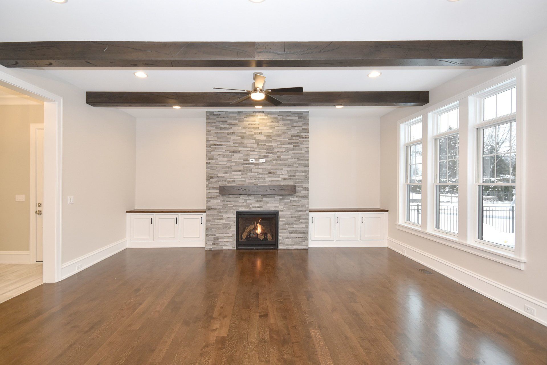 An empty living room with hardwood floors and a fireplace.