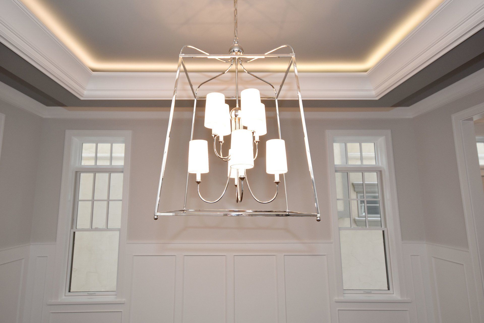 A dining room with a chandelier hanging from the ceiling