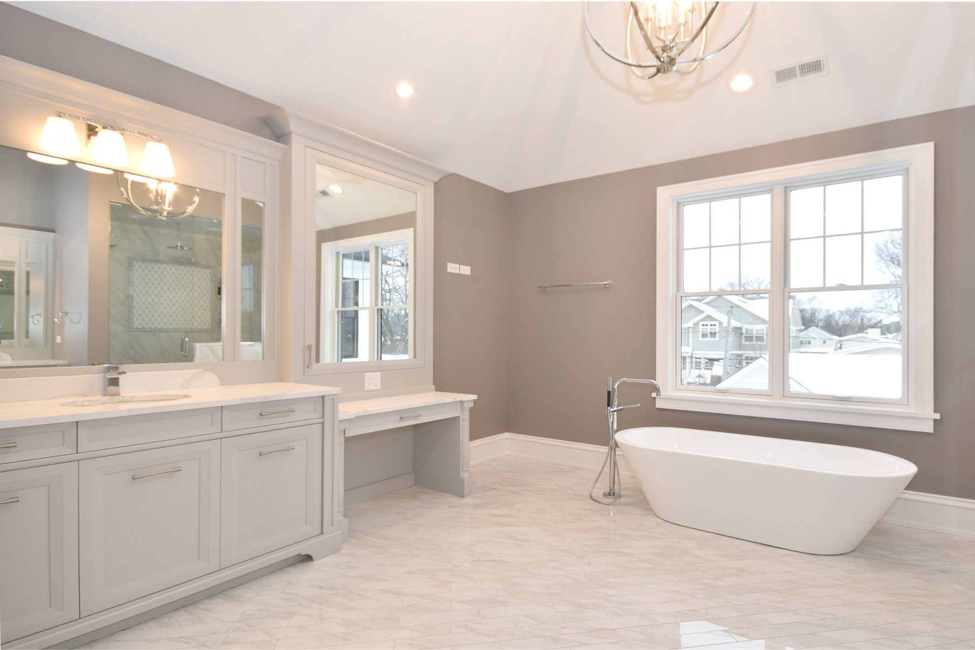 A bathroom with a tub , sinks , mirrors and windows.