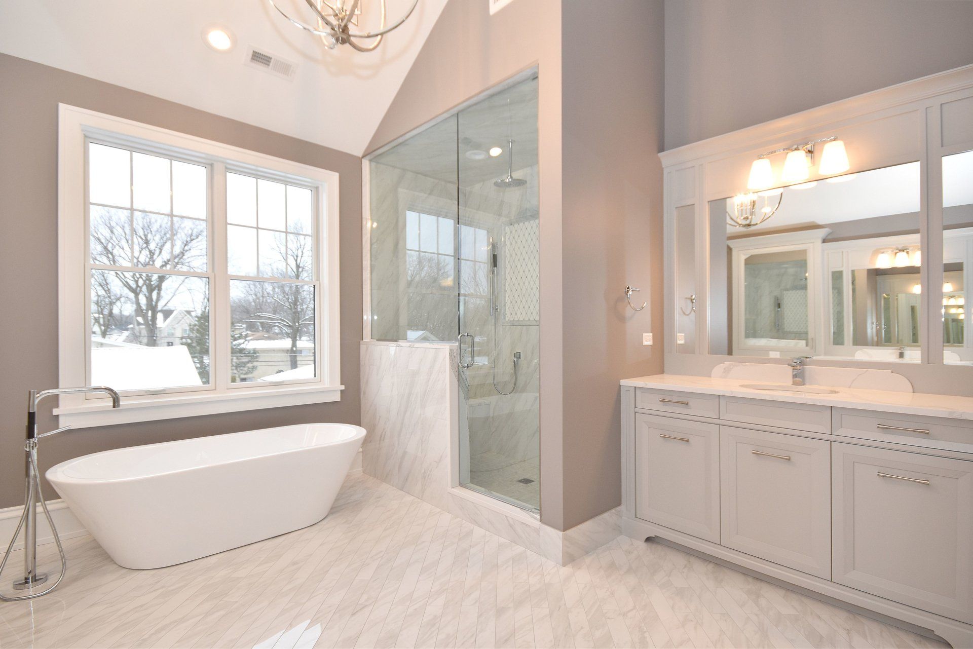 A bathroom with a tub , sinks , mirrors and a walk in shower.