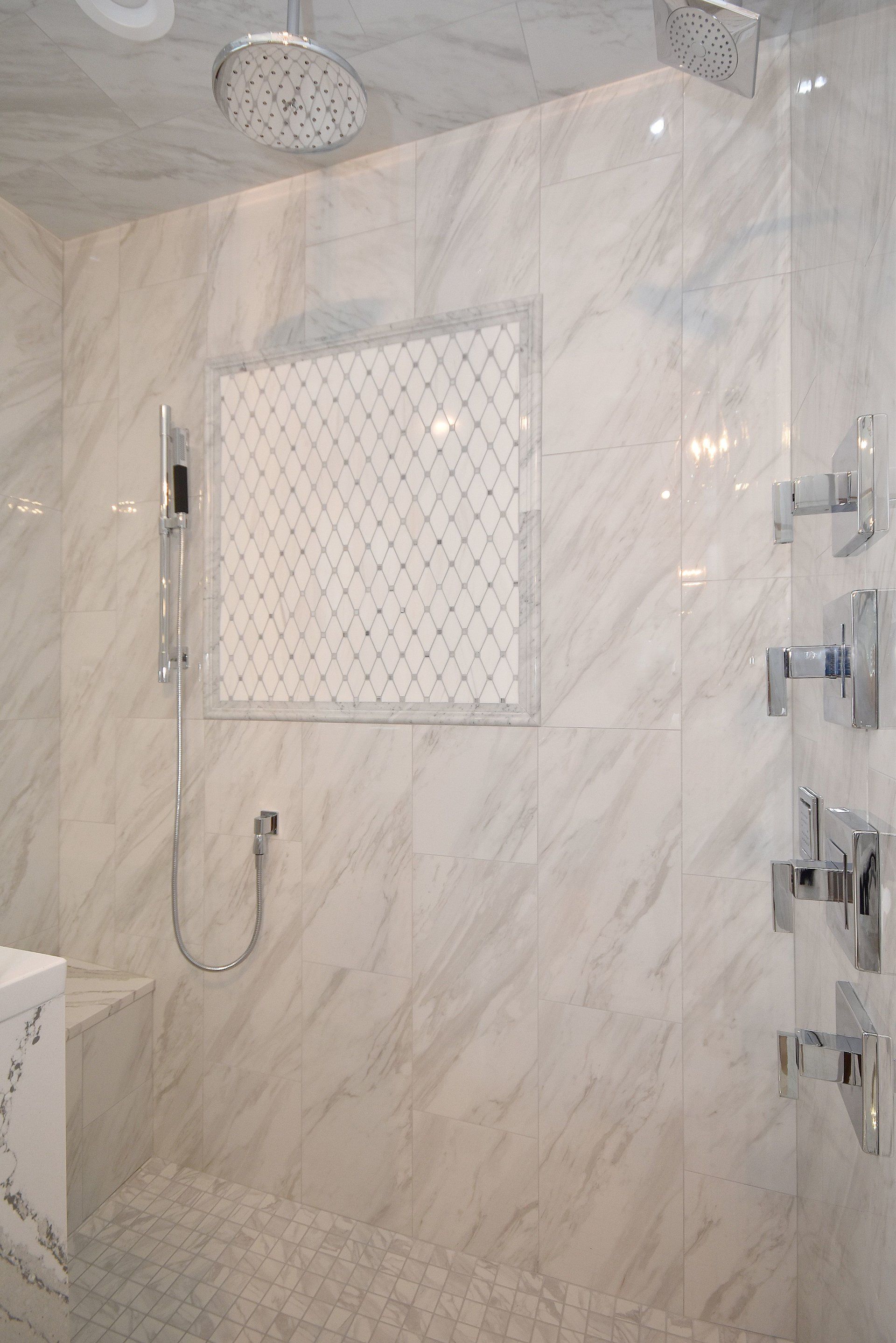 A bathroom with marble tiles and a walk in shower.