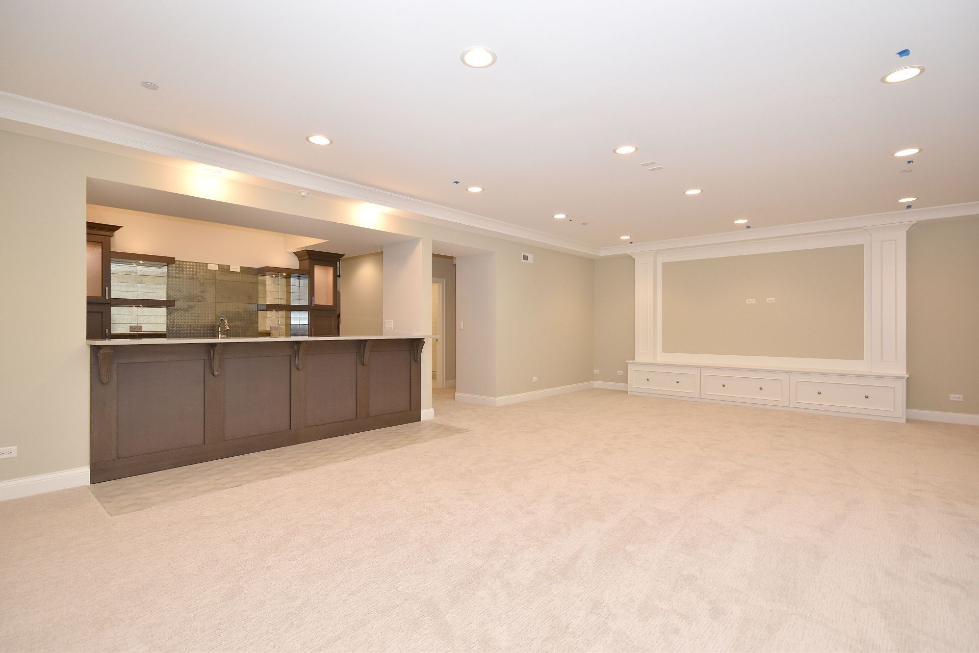 A large empty room with a bar in the middle of it.