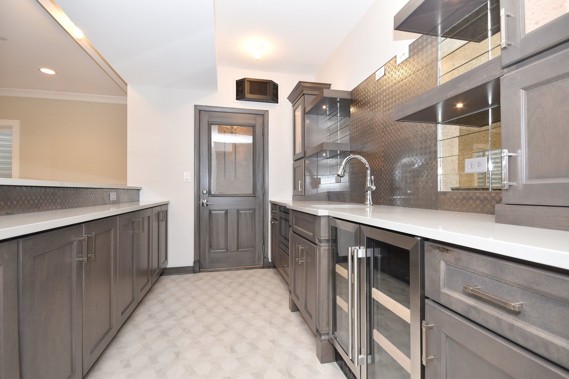 A kitchen with gray cabinets and white counter tops