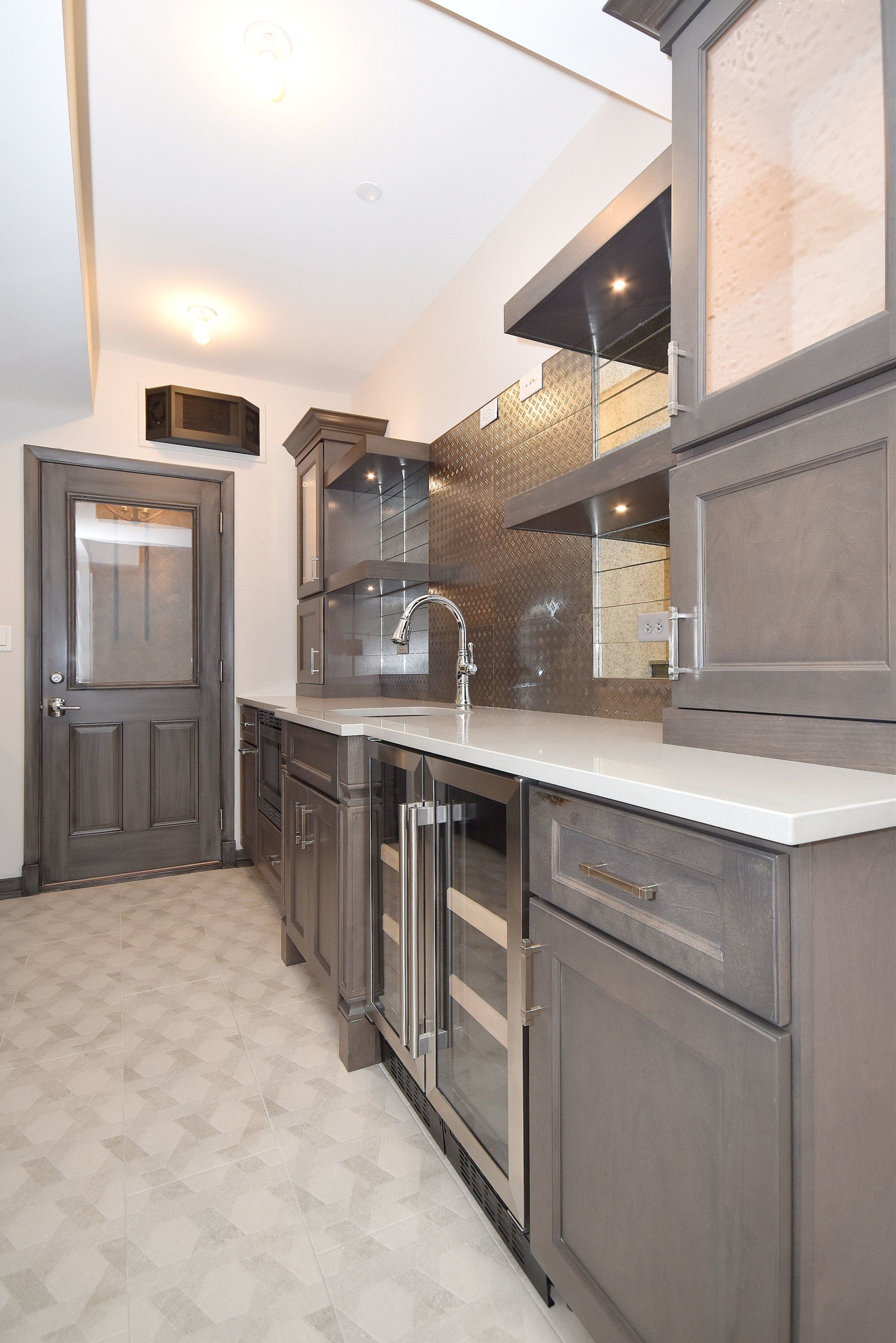 A kitchen with stainless steel appliances and gray cabinets