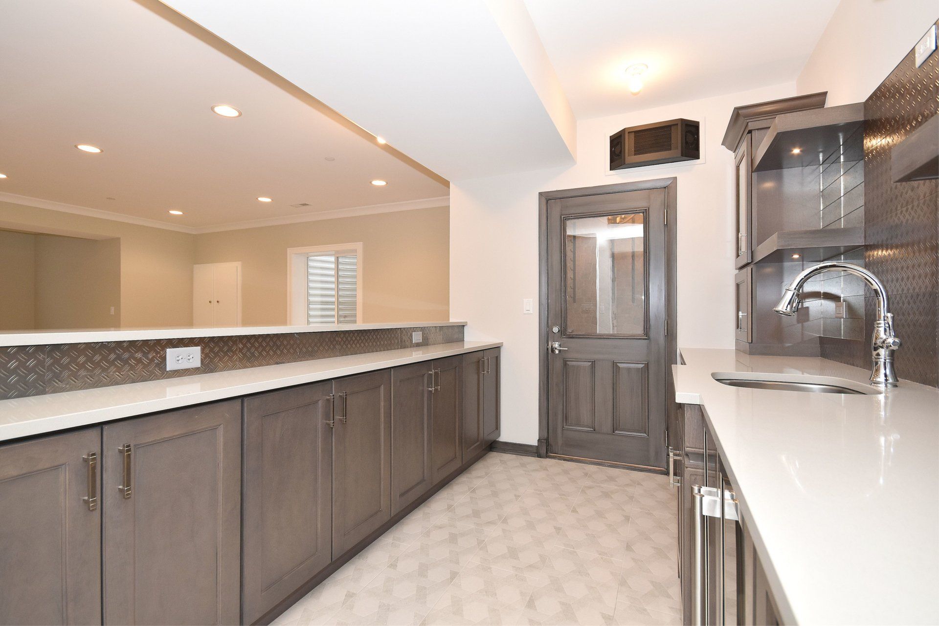 A kitchen with gray cabinets and white counter tops