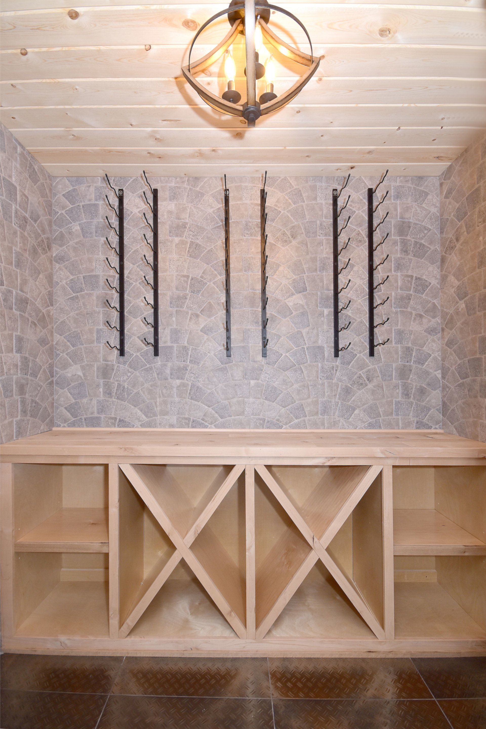 A wine cellar with wooden shelves and a chandelier hanging from the ceiling.