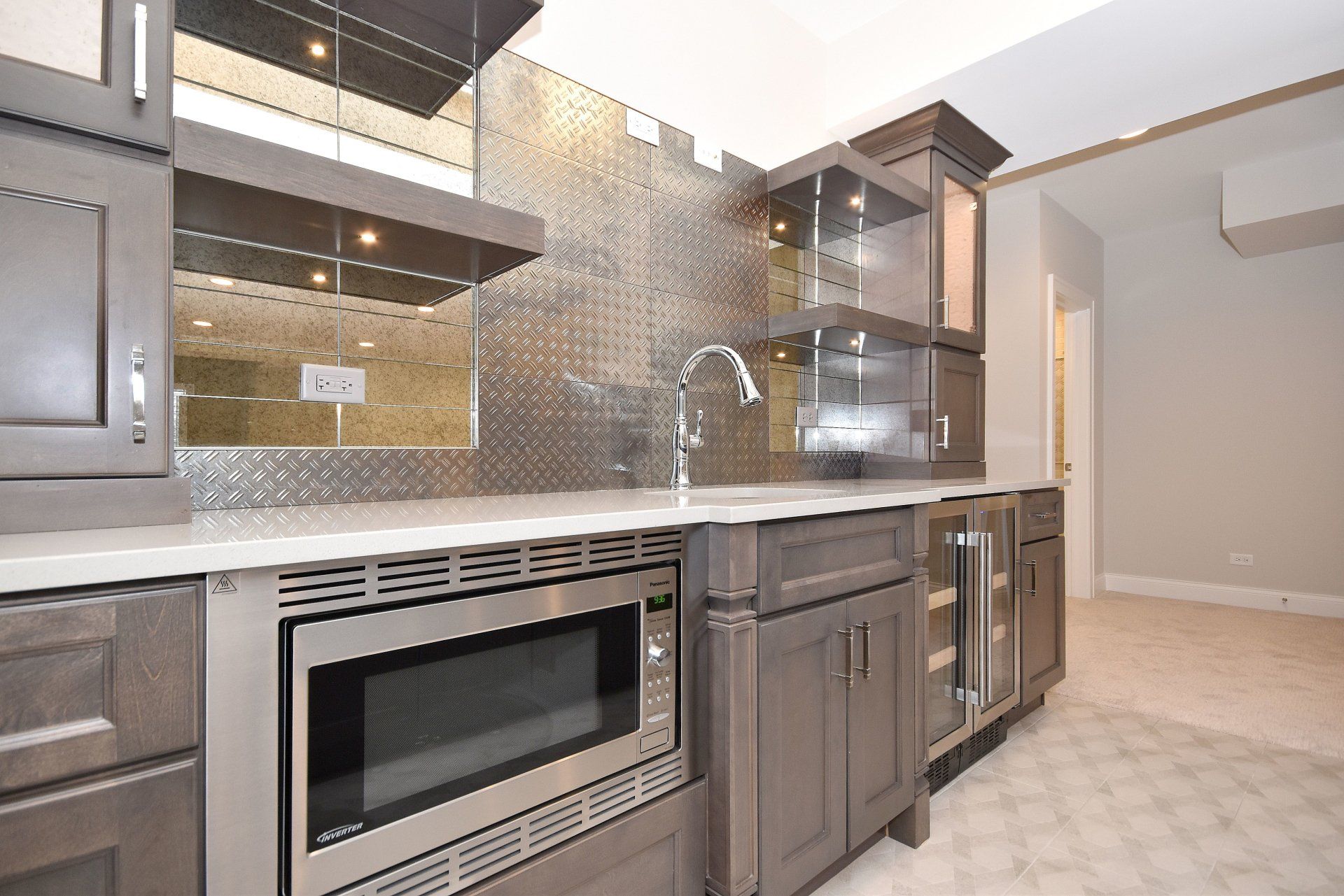 A kitchen with stainless steel appliances and gray cabinets