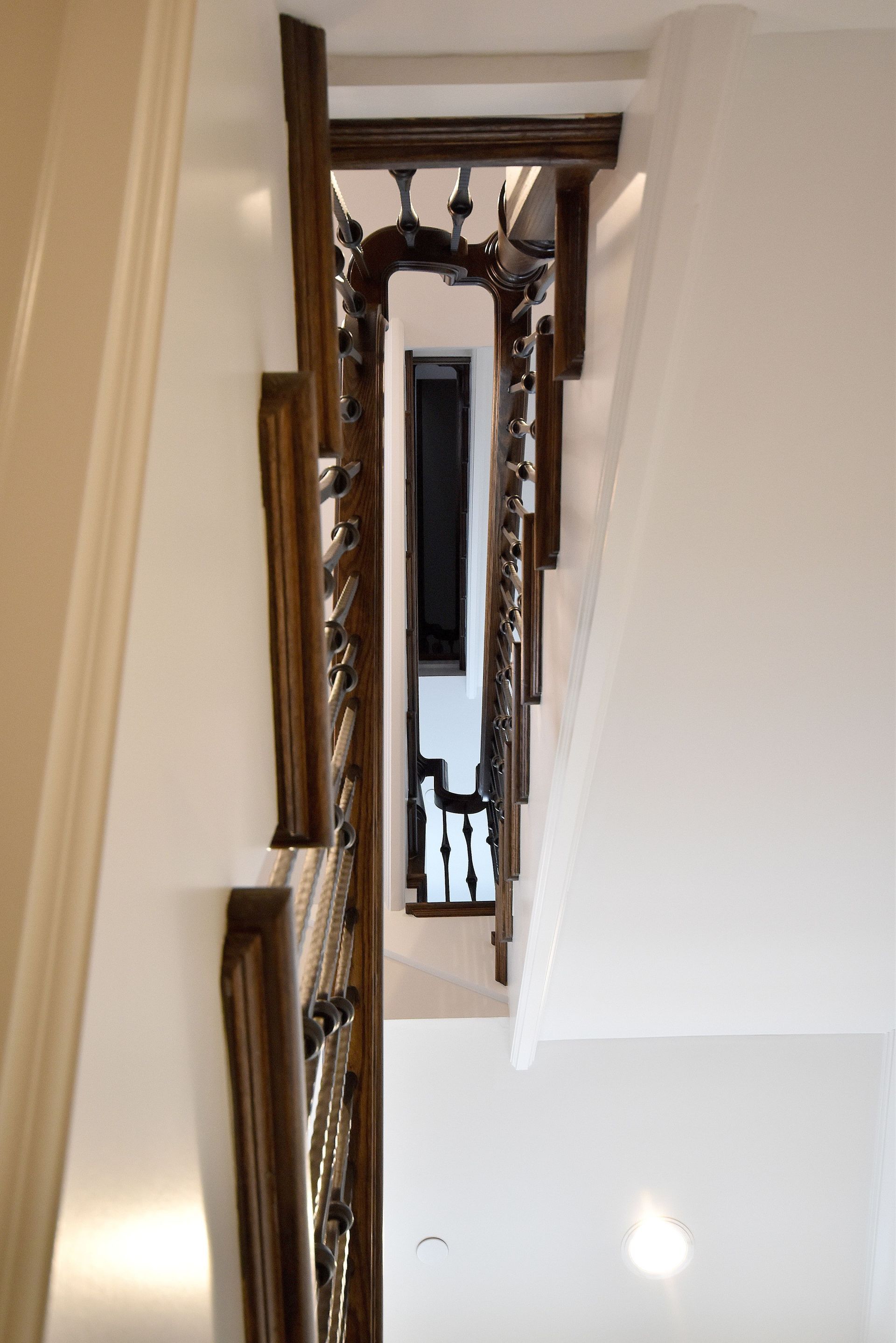 A staircase with a wooden railing leading up to the second floor of a house.