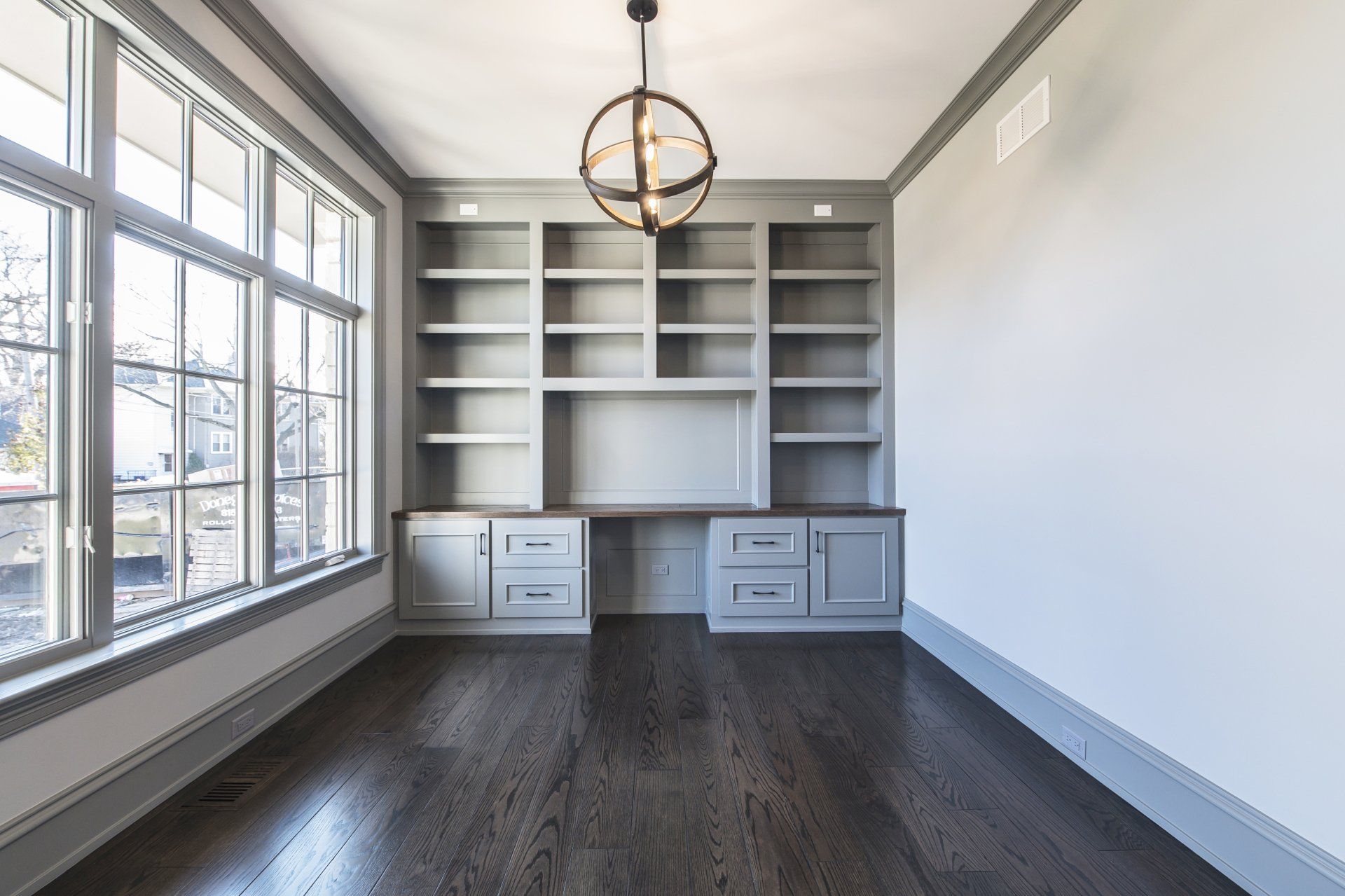 An empty room with a lot of shelves and windows