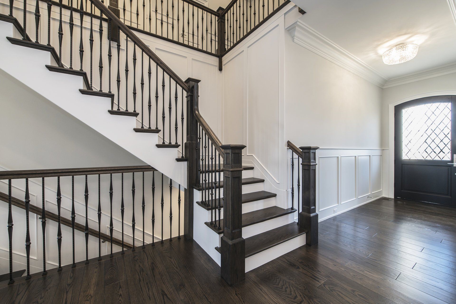 An empty hallway with a staircase and a door