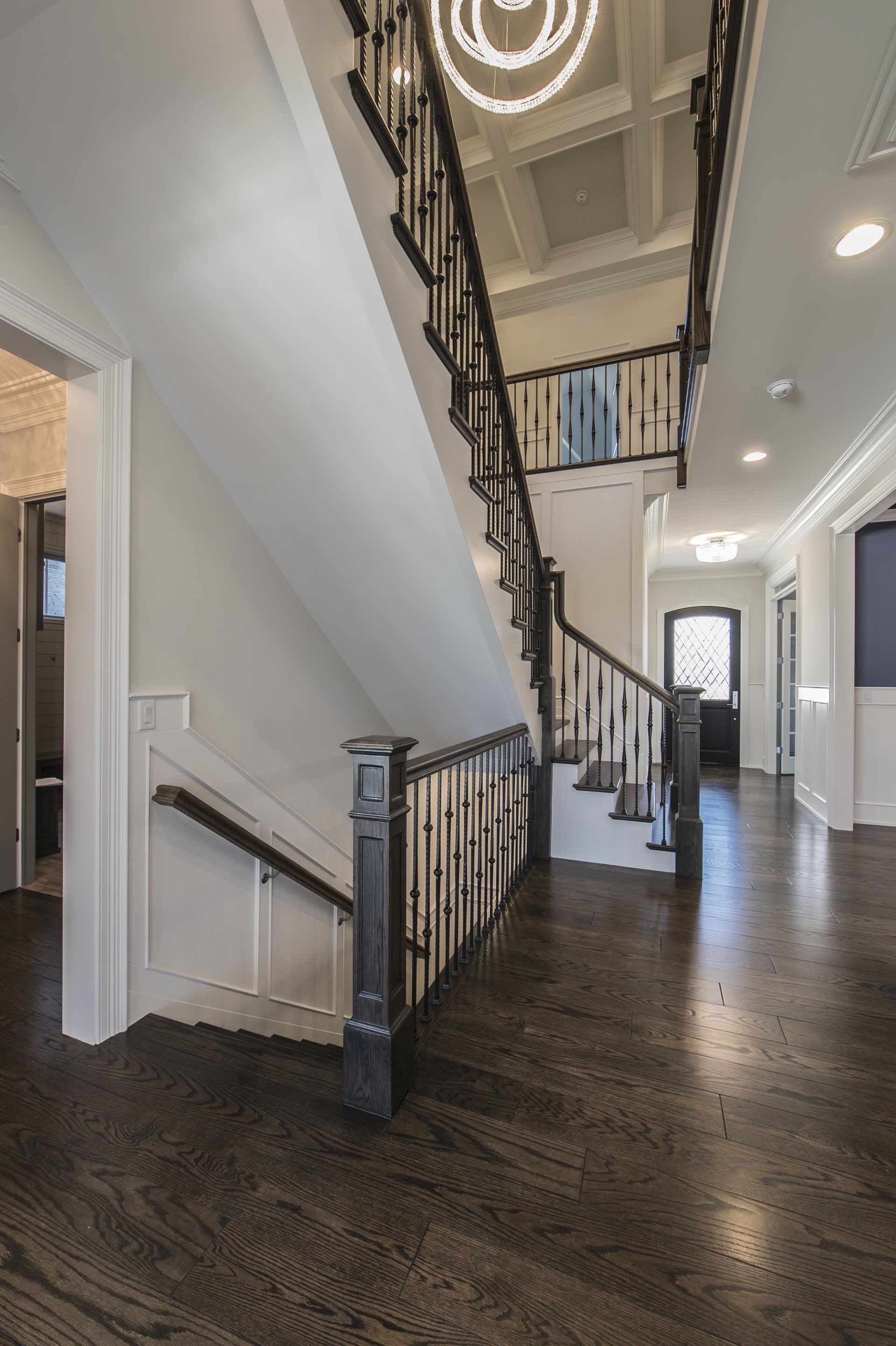 A large hallway with a staircase leading up to the second floor of a house.