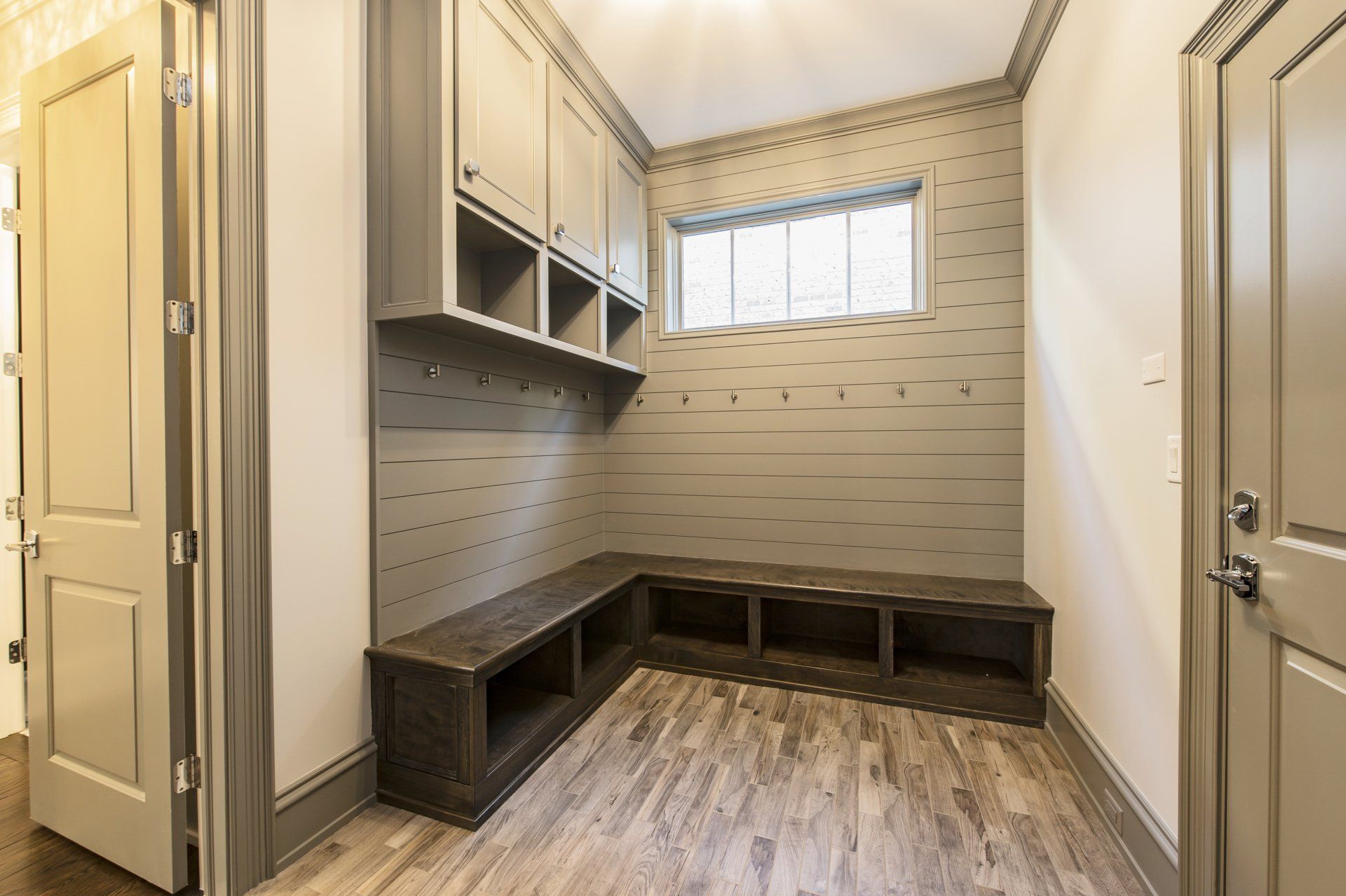 A mud room with a bench and cabinets in a house.