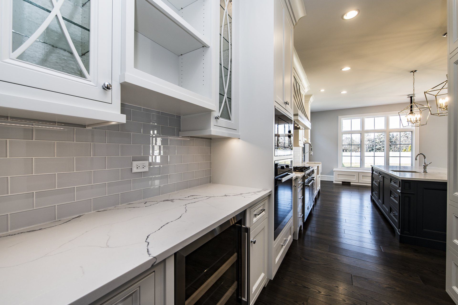 A kitchen with white cabinets and stainless steel appliances and a wine cooler.