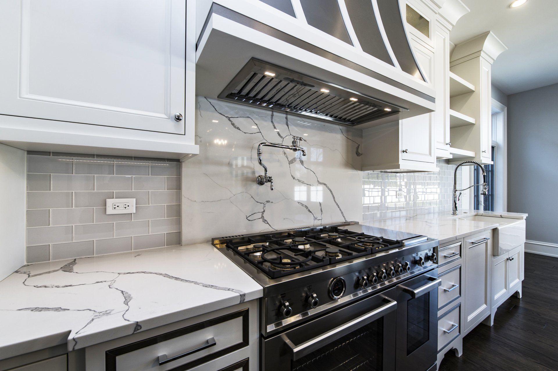 A kitchen with white cabinets and a stove top oven.