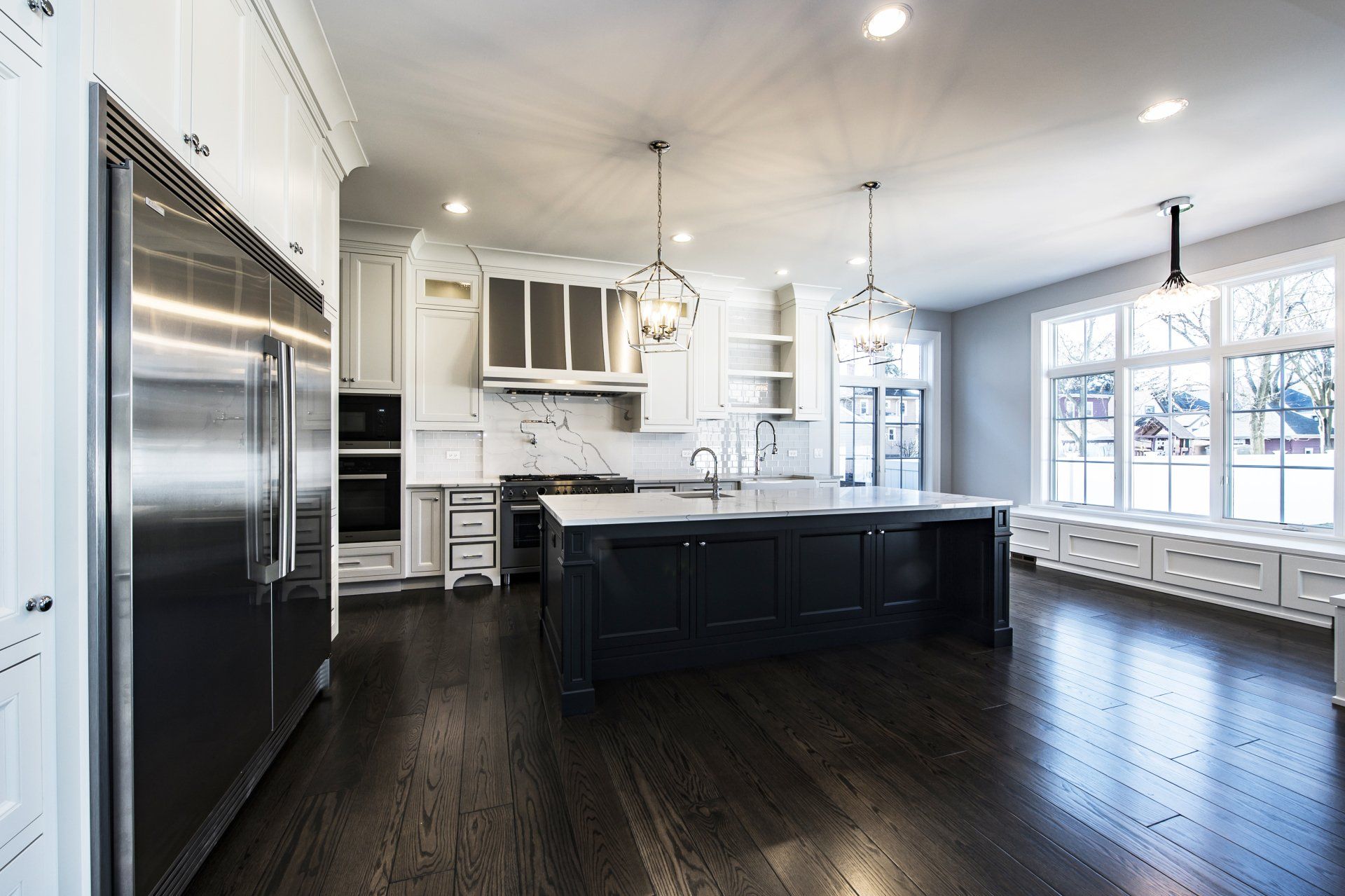 A large kitchen with black cabinets and stainless steel appliances.